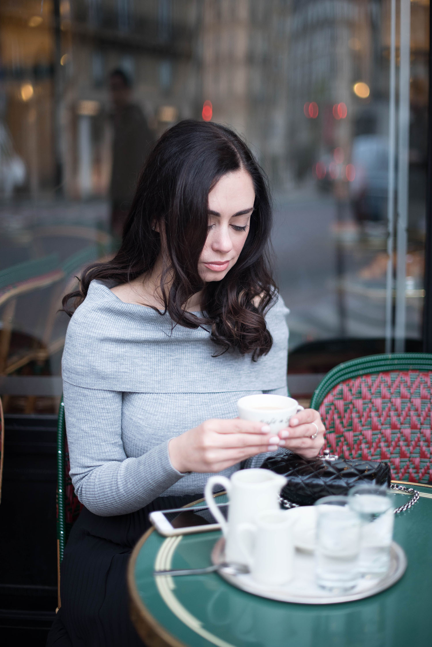 Portrait of style blogger Cee Fardoe of Coco & Vera holding a cup of coffee at the Cafe de Flore