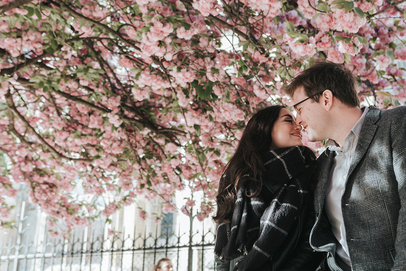 Winnipeg style blogger Cee Fardoe of Coco & Vera sits under a cherry blossom tree with her husband.