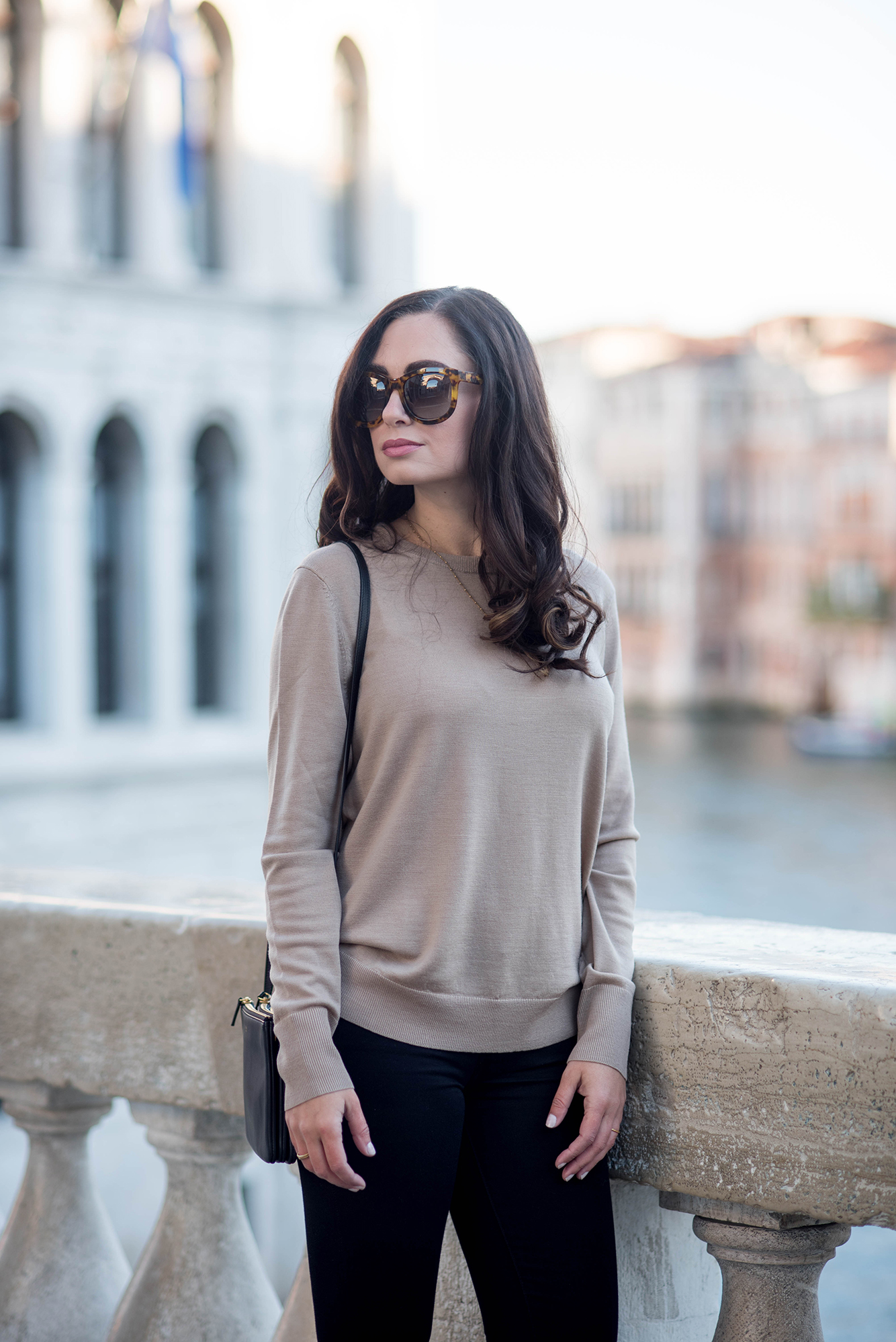 Portrait of brunette style blogger Cee Fardoe of Coco & Vera wearing Anine Bing sunglasses on Rialto Bridge in Venice