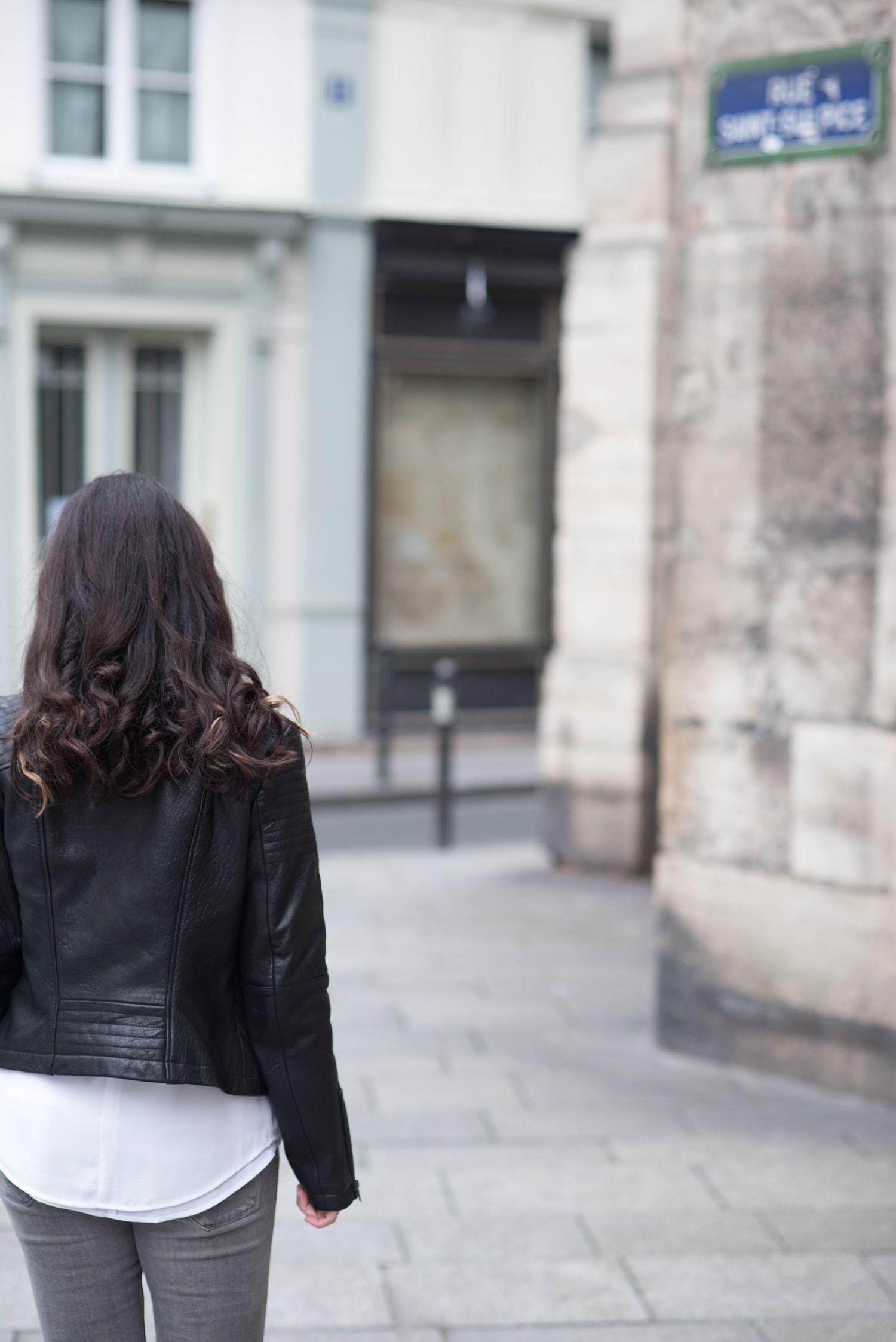 Style blogger Cee Fardoe of Coco & Vera walks on rue Saint-Sulpice in Paris wearing a leather jacket