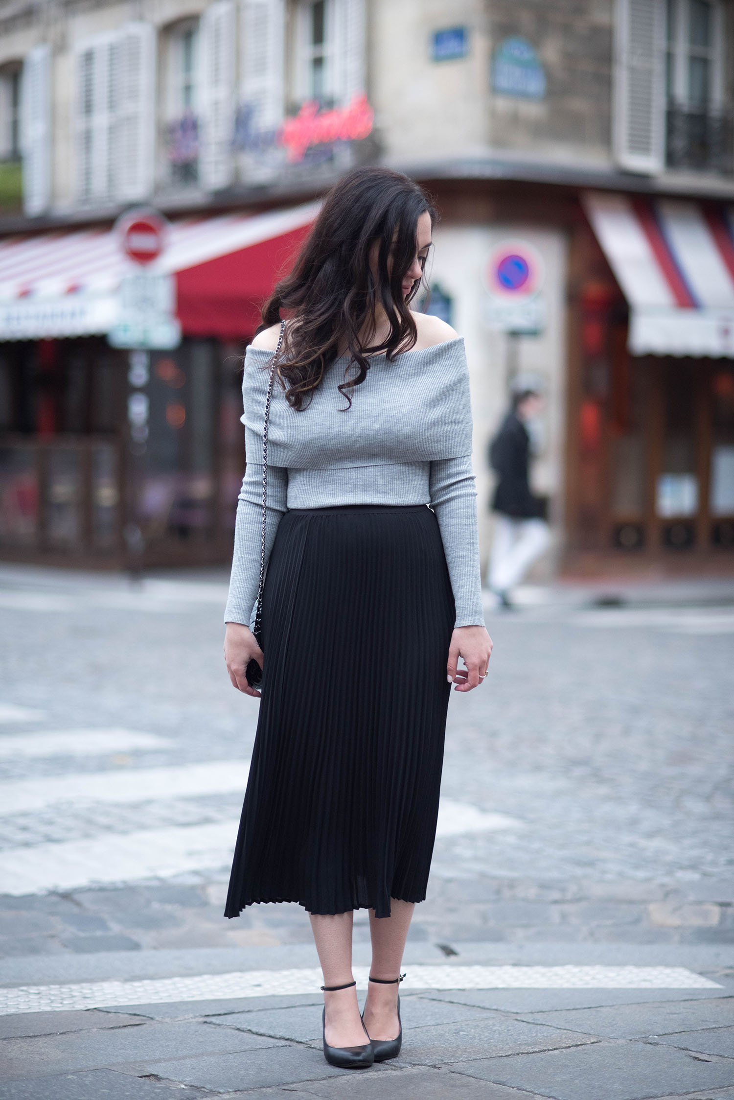 Fashion blogger Cee Fardoe of Coco & Vera wears an Aritzia pleated skirt on a left bank street in Paris