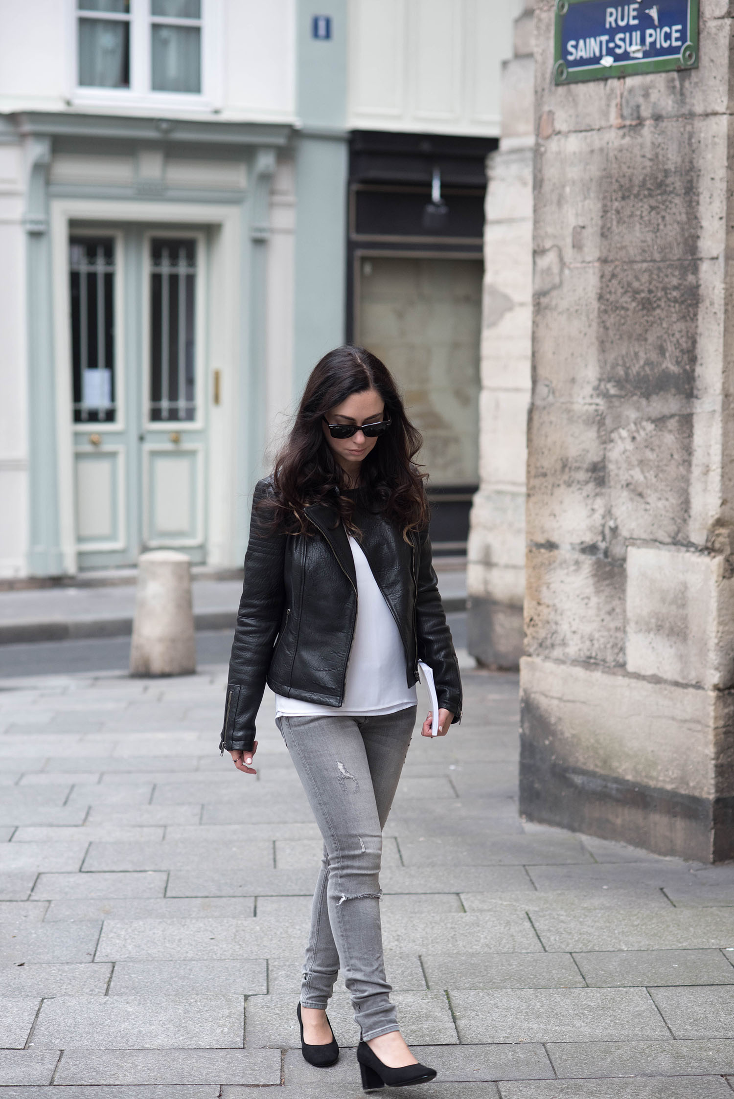 Lifestyle blogger Cee Fardoe of Coco & Vera walks in Paris wearing a leather jacket and Express Barcelona tank