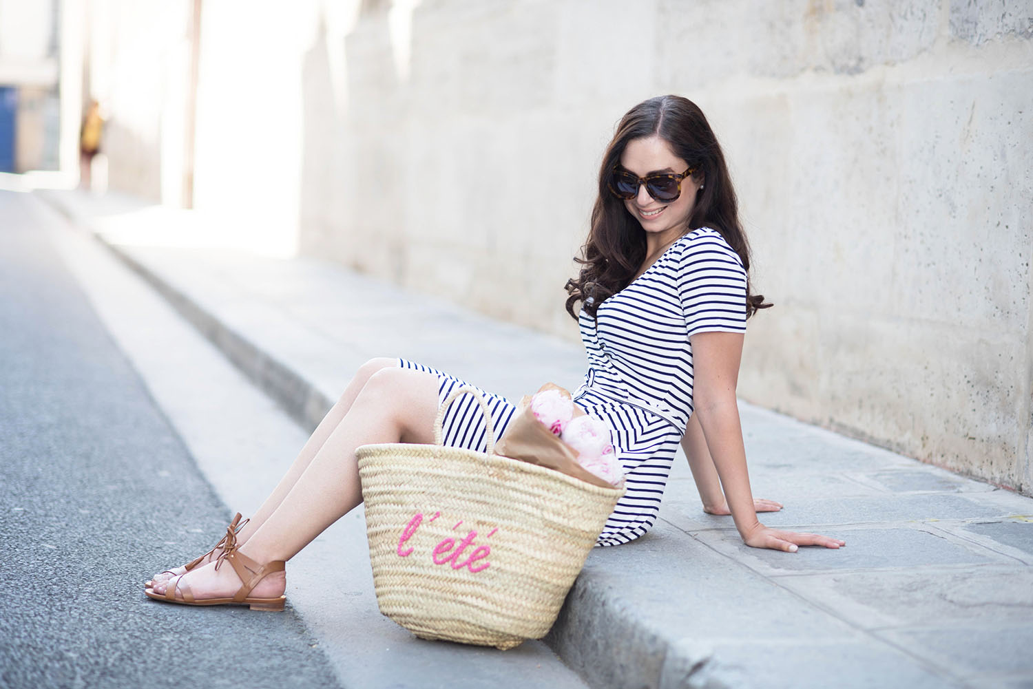 Style blogger Cee Fardoe of Cooc & Vera sits on the street in le Marais with a Sezane l'ete straw tote