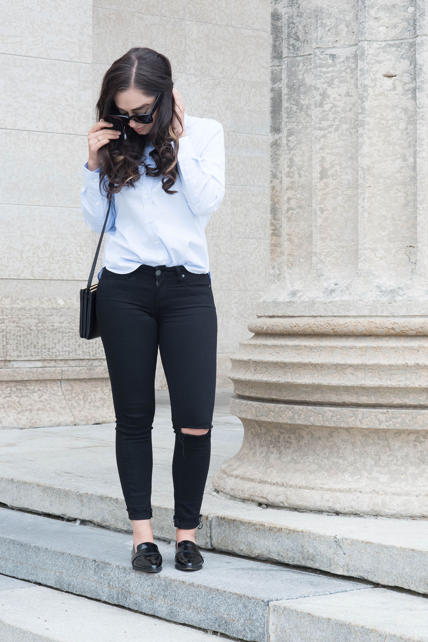 Fashion blogger Cee Fardoe of Coco & Vera stands at the Manitoba Legislature wearing Charles & Keith Loafers and Paige Denim jeans