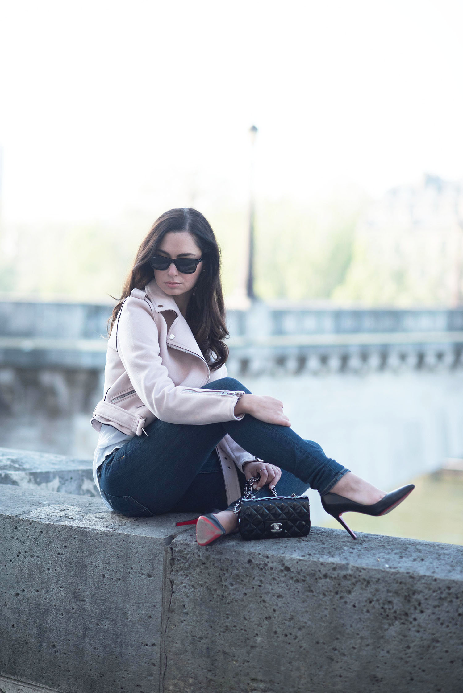 Style blogger Cee Fardoe of Coco & Vera sits on the quad in Paris wearing Christian Louboutin Pigalle pumps and pink Zara jacket