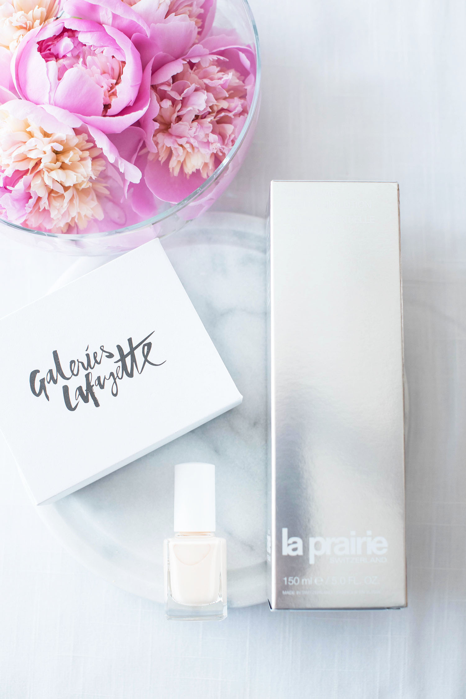 Silver La Prairie box next to a bowl of peonies, photographed by beauty blogger Cee Fardoe of Coco & Vera
