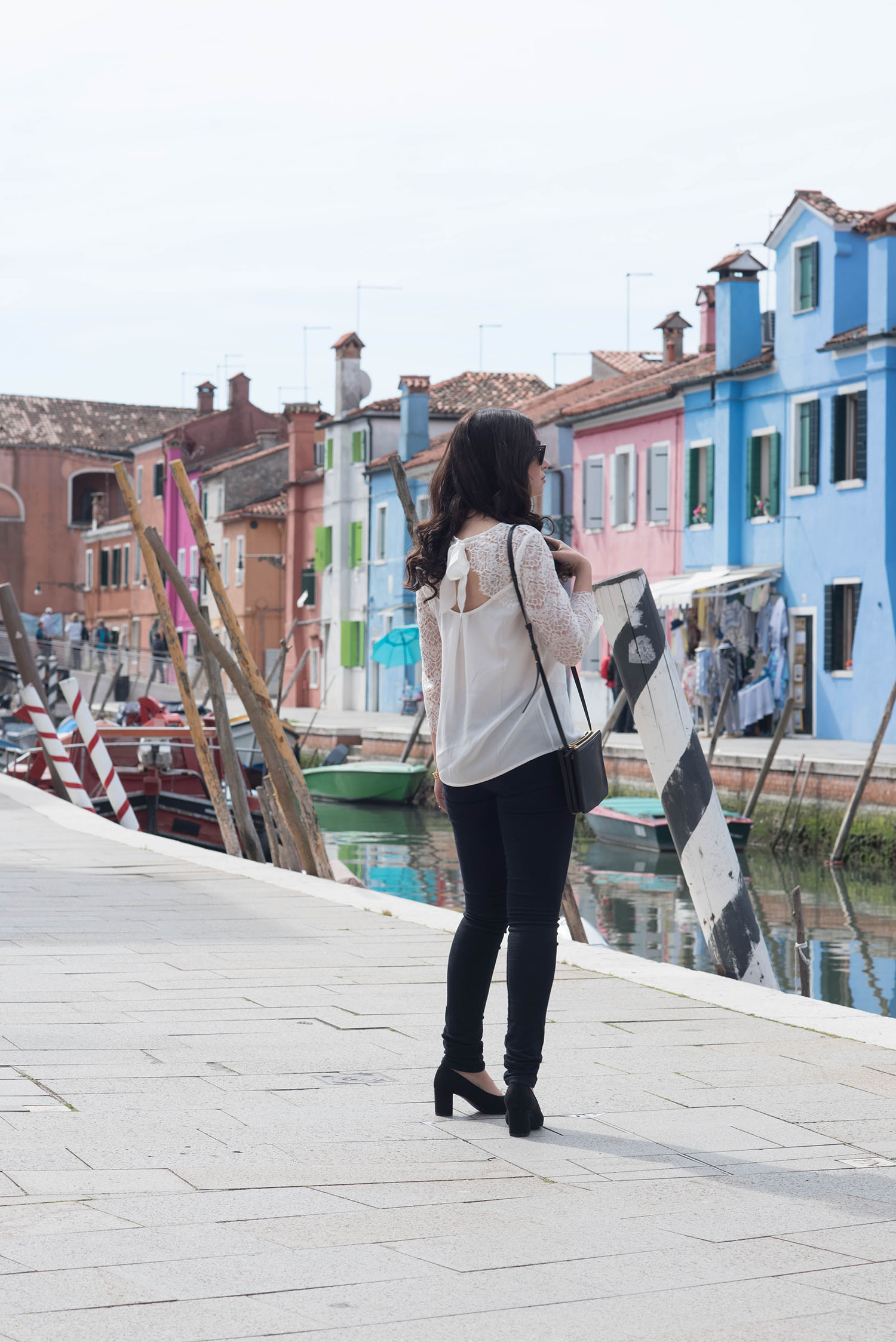 Fashion blogger Cee Fardoe of Coco & Vera walks on Burano carrying a Celine trio bag and wearing a Sezane lace blouse