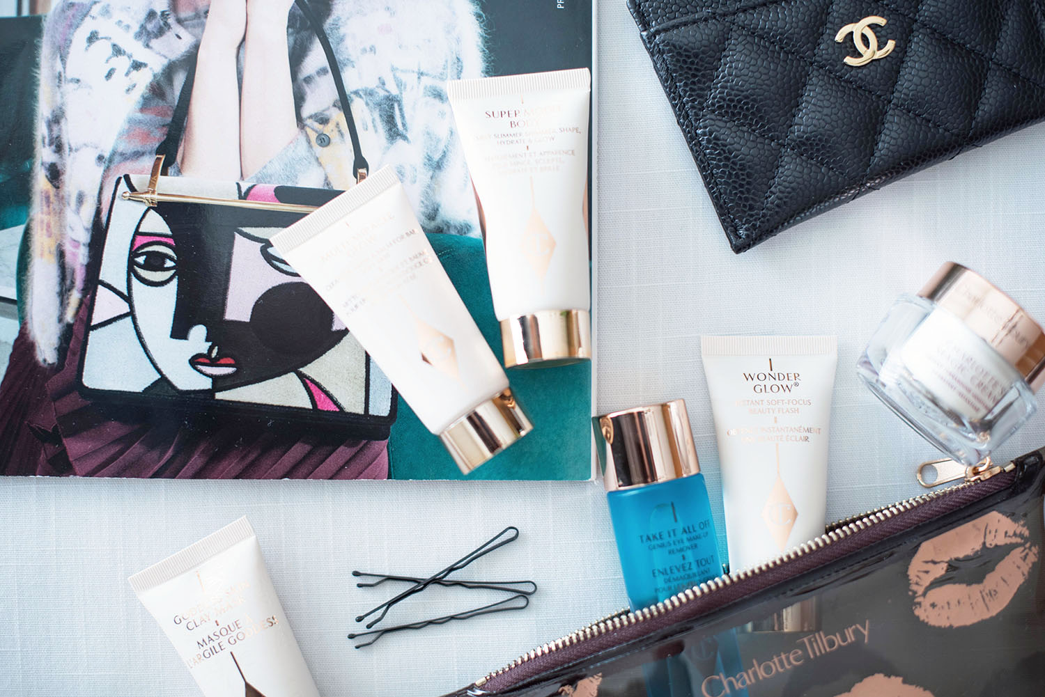Products from the Charlotte Tilbury Gift of Red Carpet Skin set laid out with a copy of Vogue and a Chanel cardholder, captured by beauty blogger Cee Fardoe of Coco & Vera