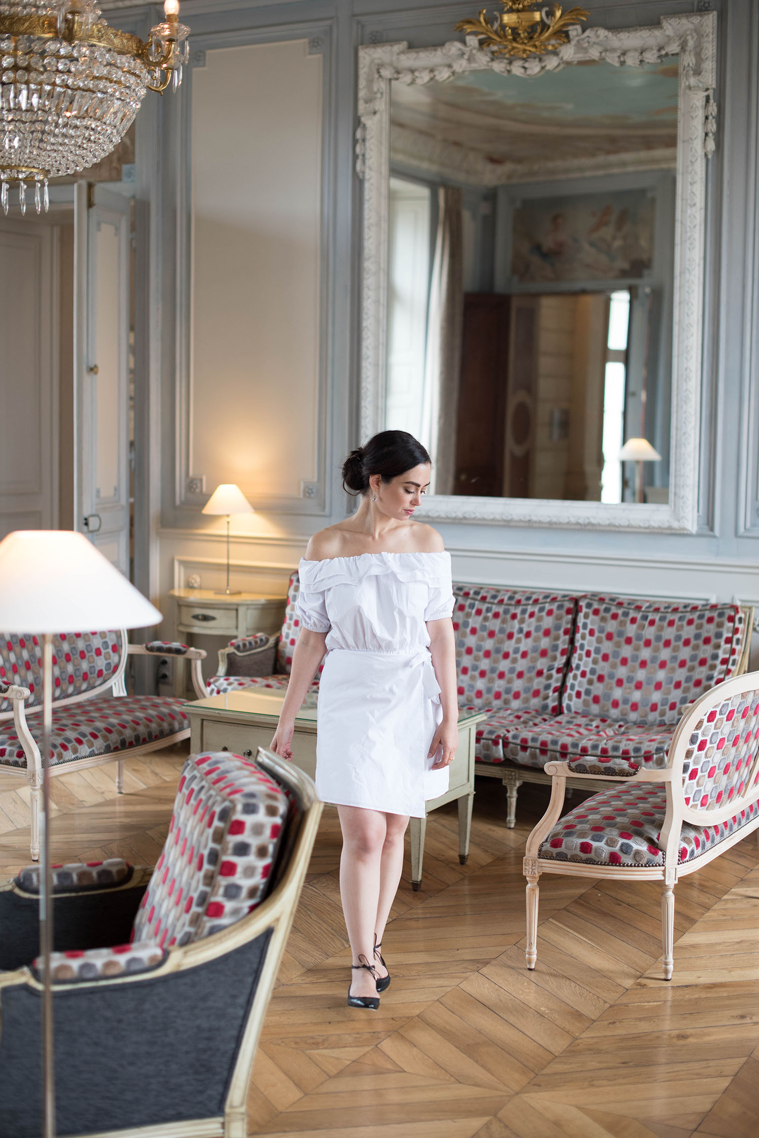 Canadian fashion blogger Cee Fardoe of Coco & Vera walks through the ballroom at Chateau Sainte-Sabine wearing Jimmy Choo lace-up flats