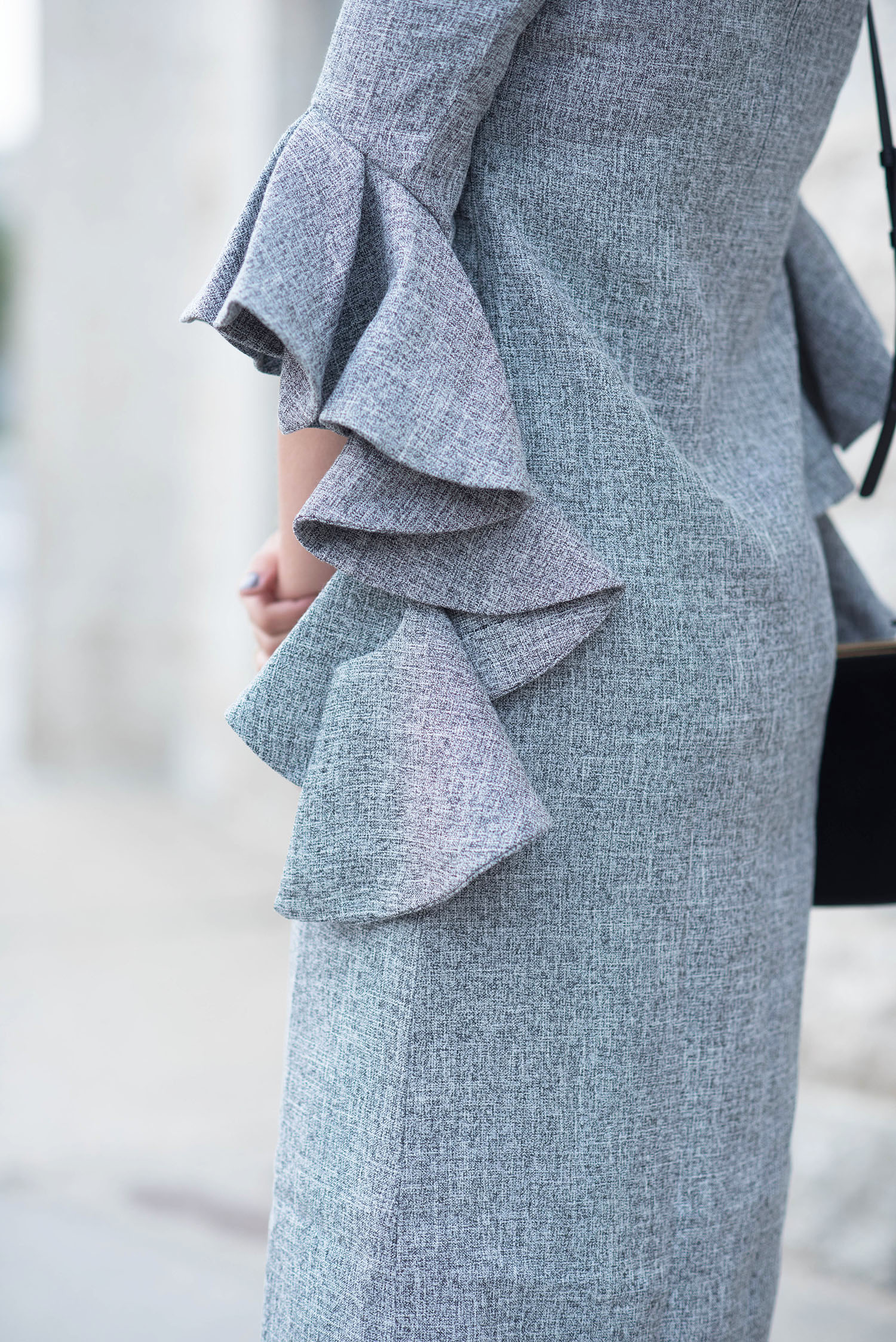 Outfit details on fashion blogger Cee Fardoe of Coco & Vera wearing a grey ruffle sleeve dress from Metisu