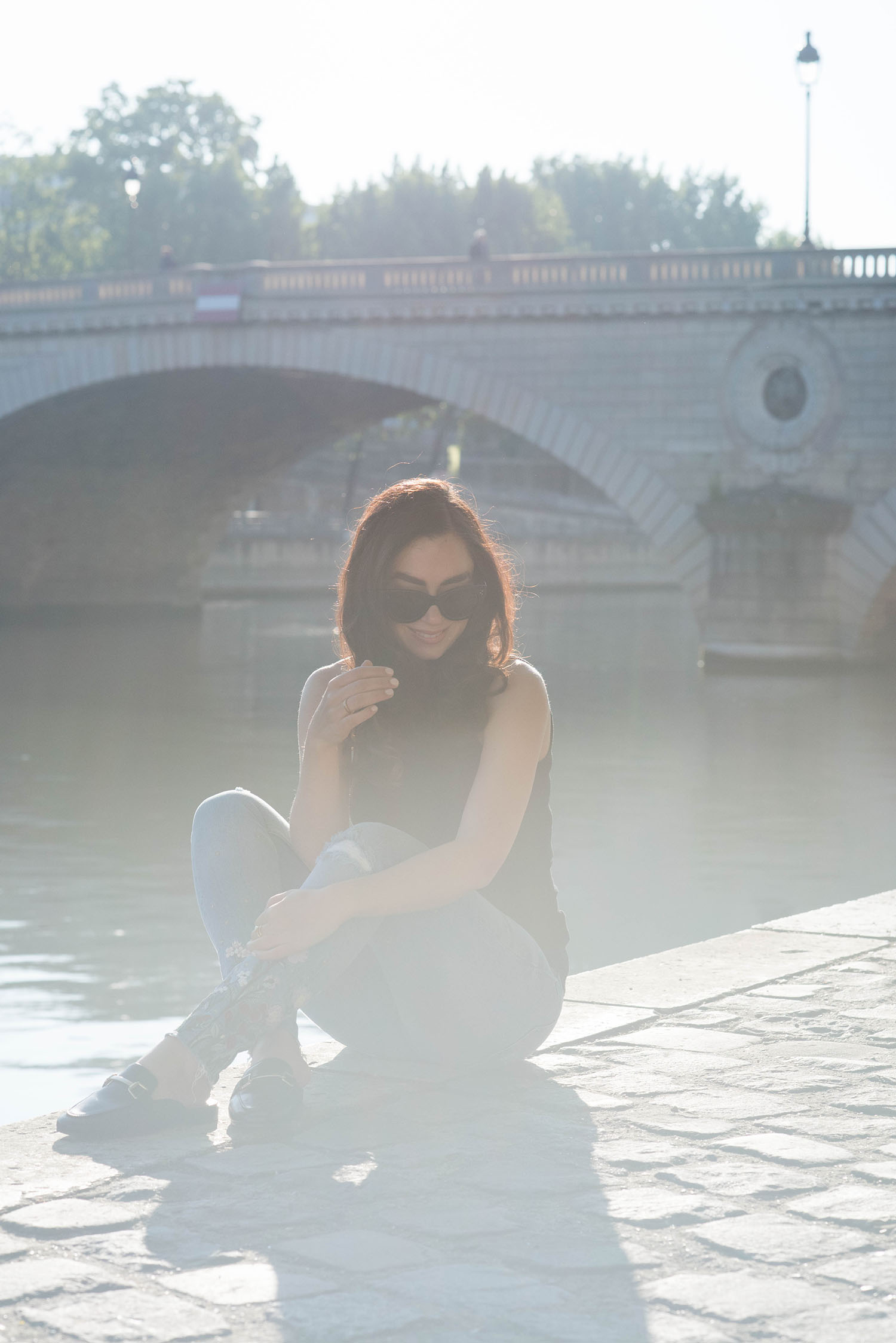 Canadian style blogger Cee Fardoe of Coco & Vera sits on the quai de la Seine in Paris wearing Jonak mules and Zara embroidered jeans
