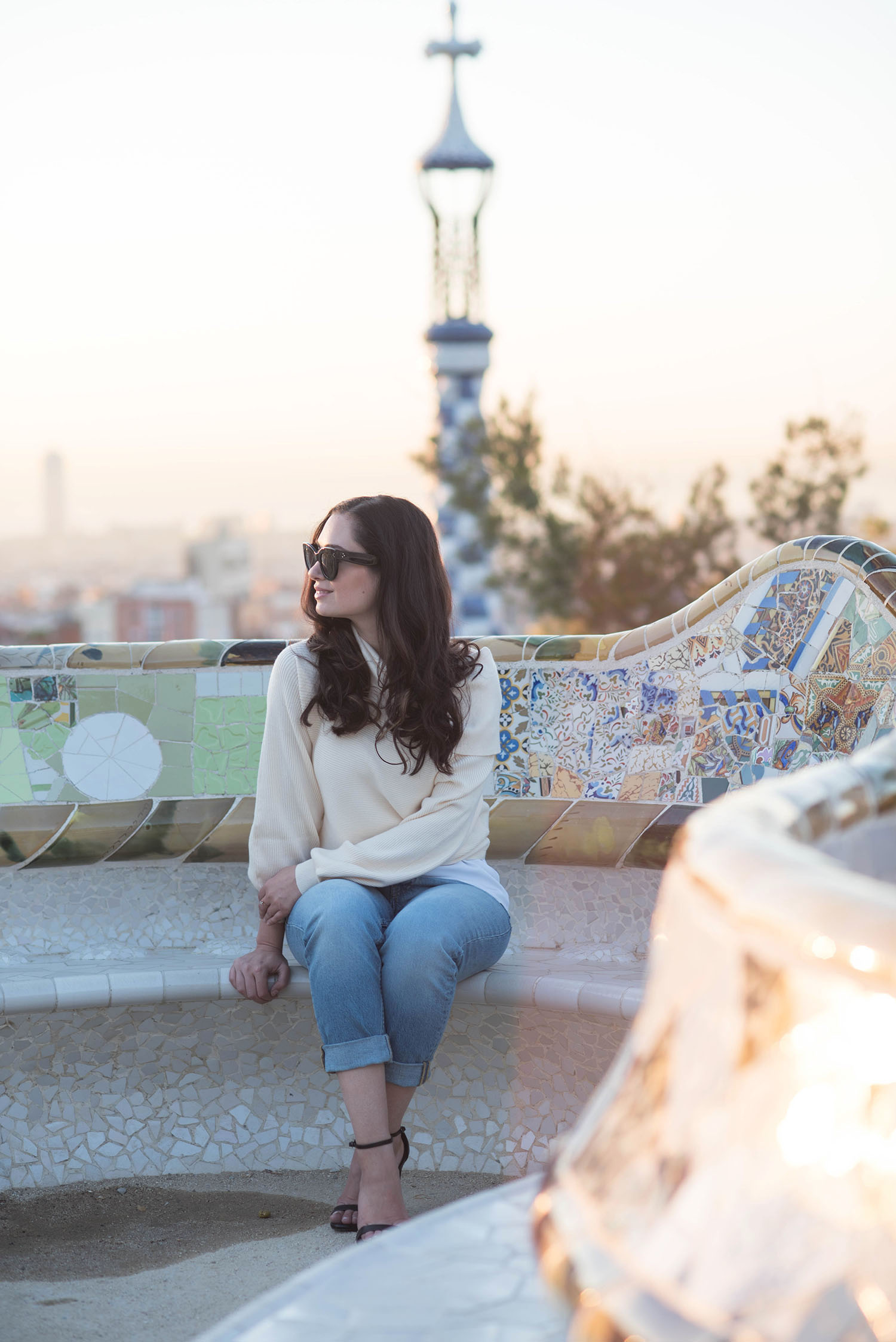 Winnipeg fashion blogger Cee Fardoe of Coco & Vera sits on a tile bench at Parc Guell wearing Celine Audrey sunglasses and Steve Madden Stecy sandals