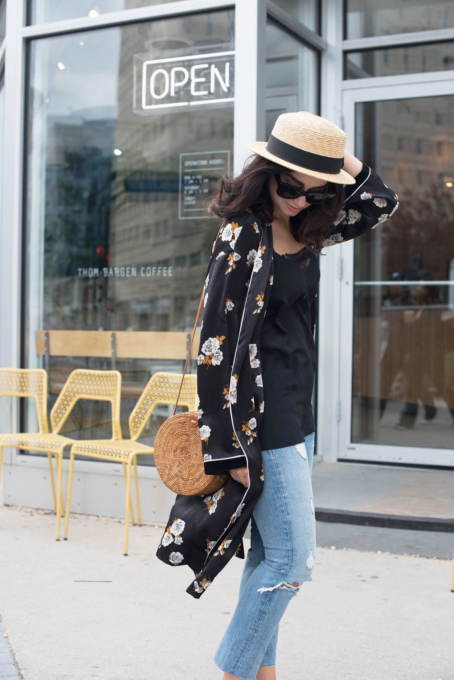 Fashion blogger Cee Fardoe of Coco & Vera holds onto her straw hat outside Thom Bargan coffee, wearing Grlfrnd Karolina jeans and a Zara black kimono