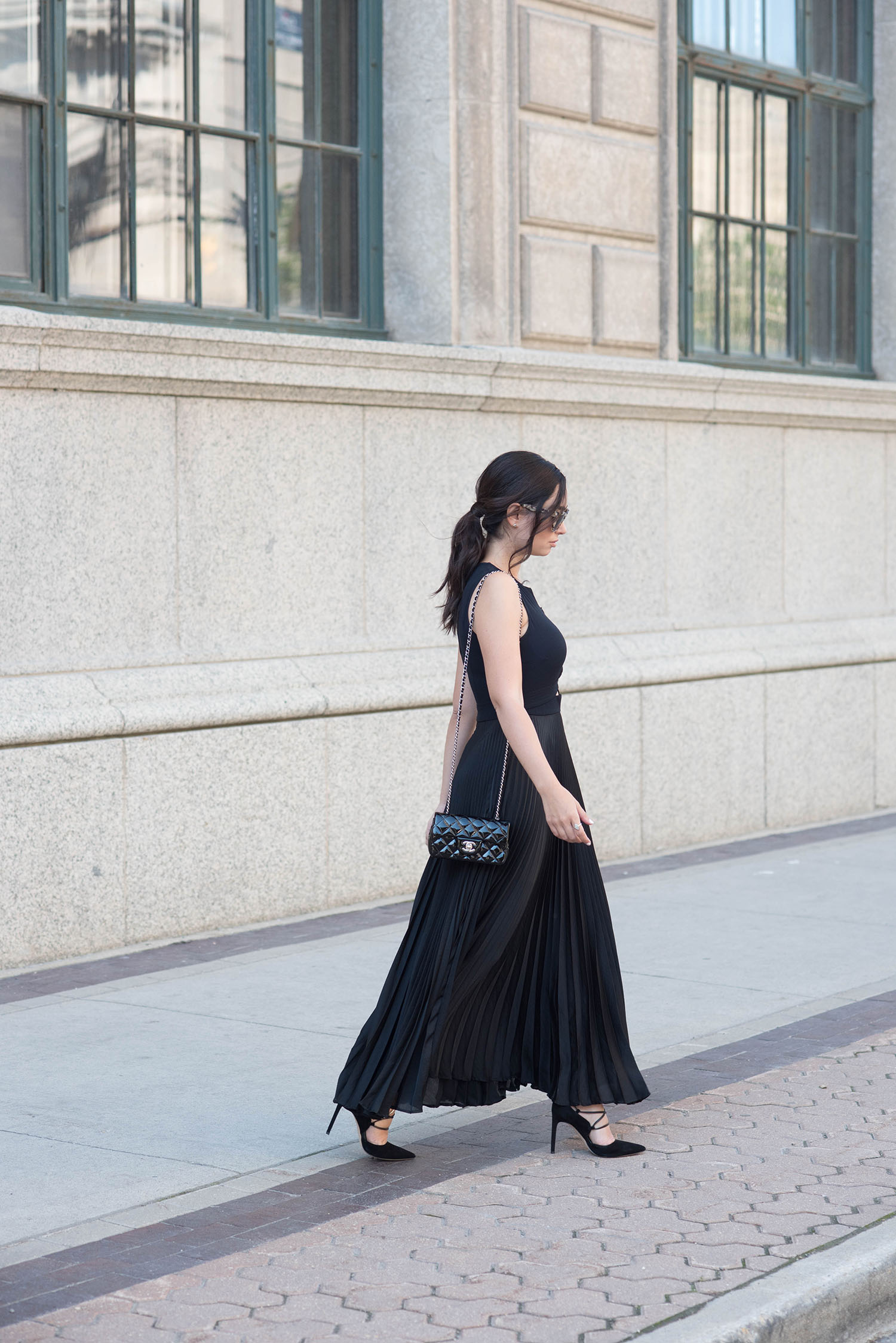 Winnipeg fashion blogger Cee Fardoe of Coco & Vera walks in the Exchange District wearing a black ALC gown and carrying a Chanel extra mini handbag