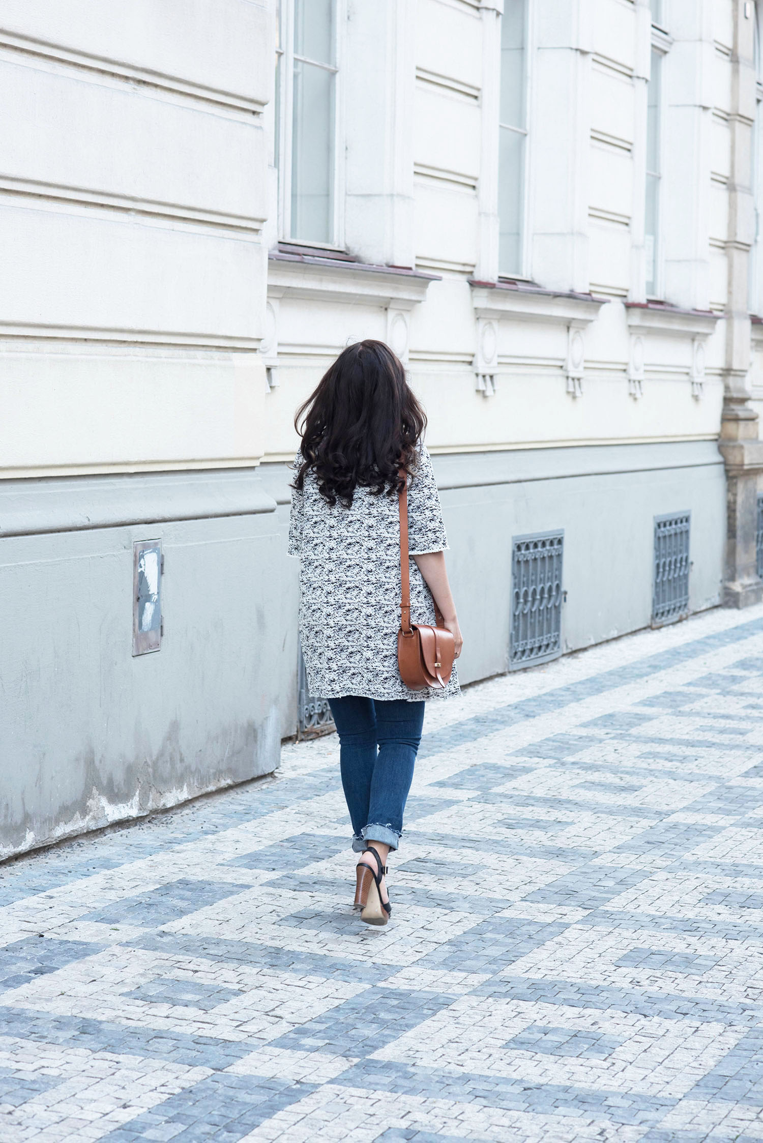 Fashion blogger Cee Fardoe of Coco & Vera walks down a Prague street wearing a Floriane Fosso coat and carrying a Sezane Claude bag