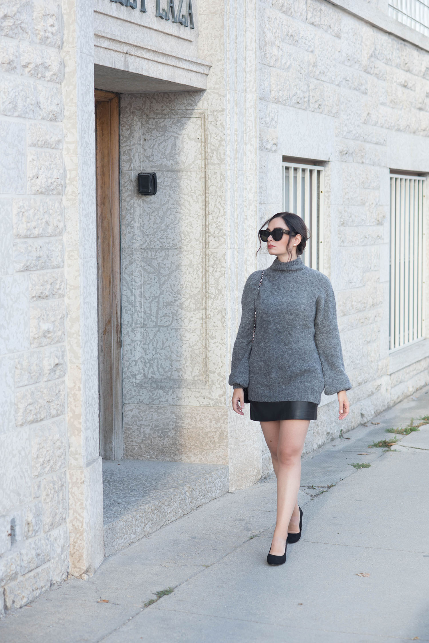 Fashion blogger Cee Fardoe of Coco & Vera walks along Mall Plazain Winnipeg wearing a Sezane leather miniskirt and H&M block heels