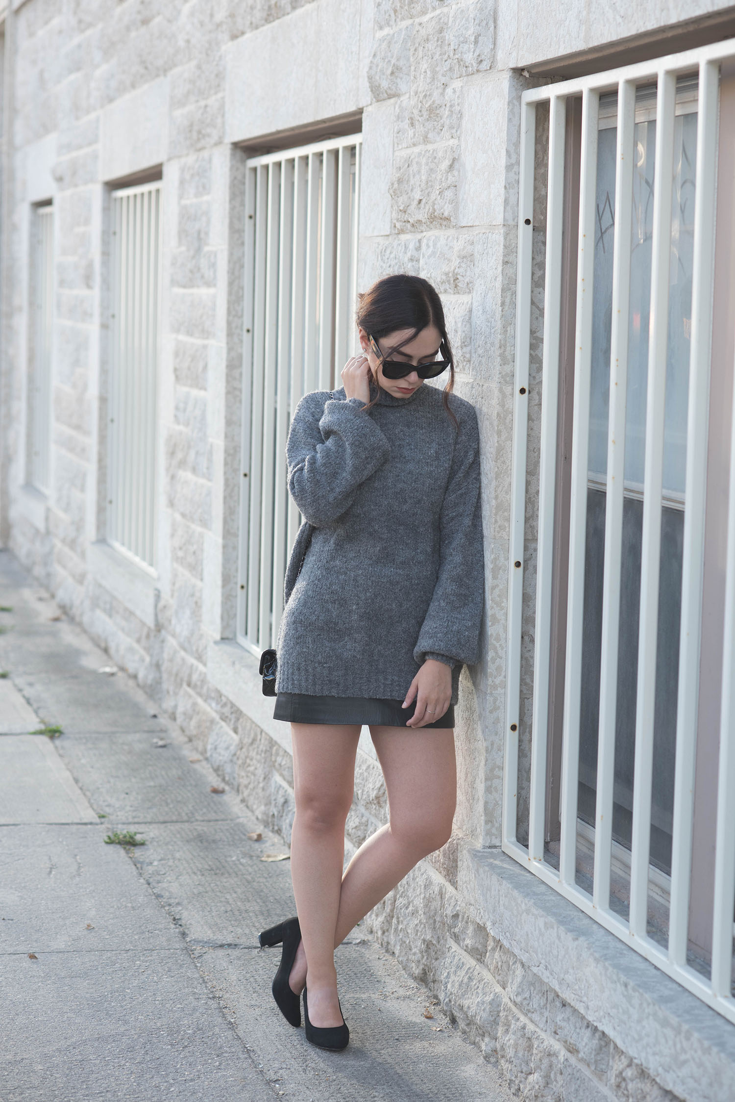Fashion blogger Cee Fardoe of Coco & Vera wears a grey Lovers + Friends LTA turtleneck sweater, Celine Audrey sunglasses and a Sezane leather skirt