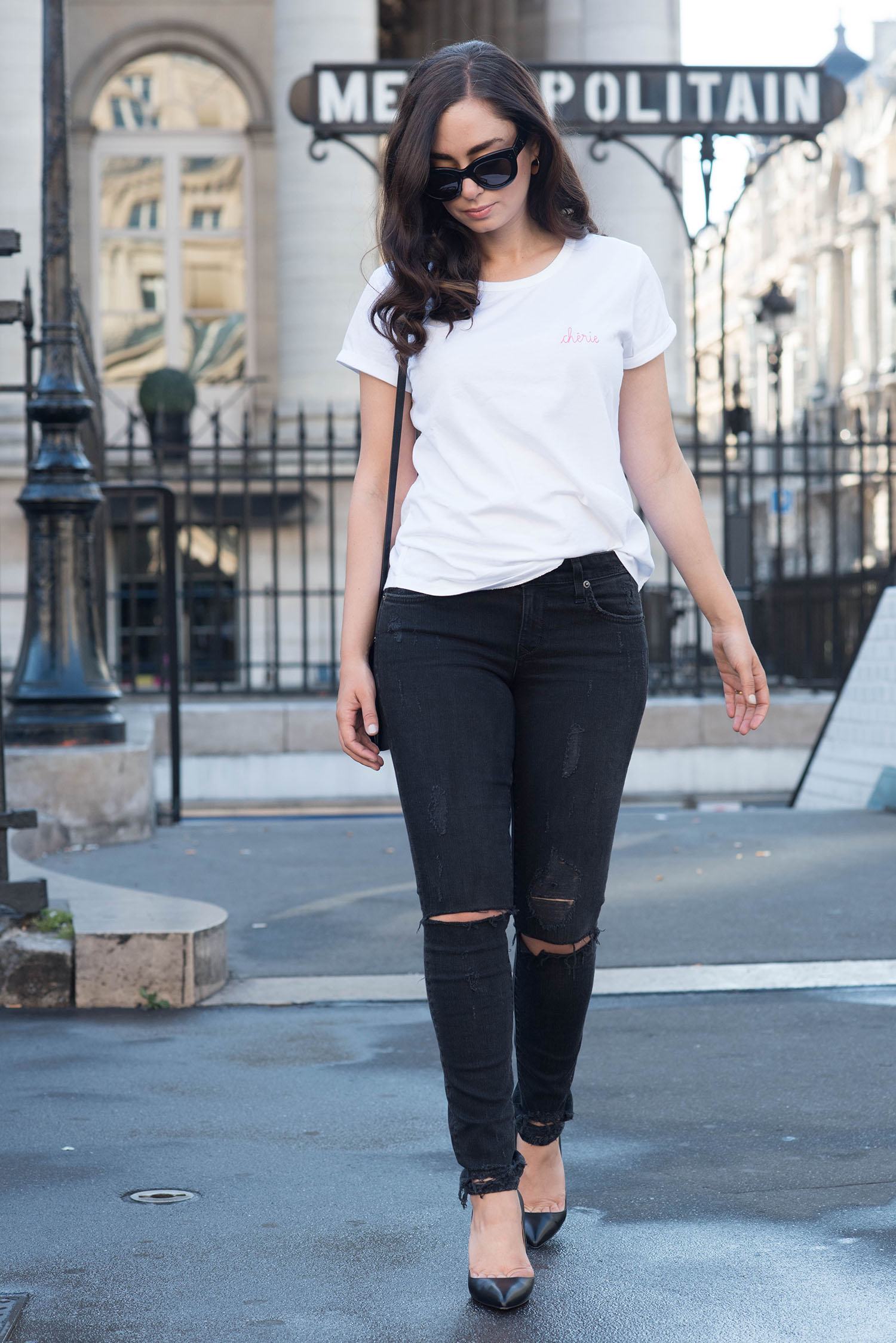 Winnipeg fashion blogger Cee Fardoe of Coco & Vera walks through Paris wearing a Maison Labiche tee, Lovers + Friends jeans and Christian Louboutin Pigalle pumps