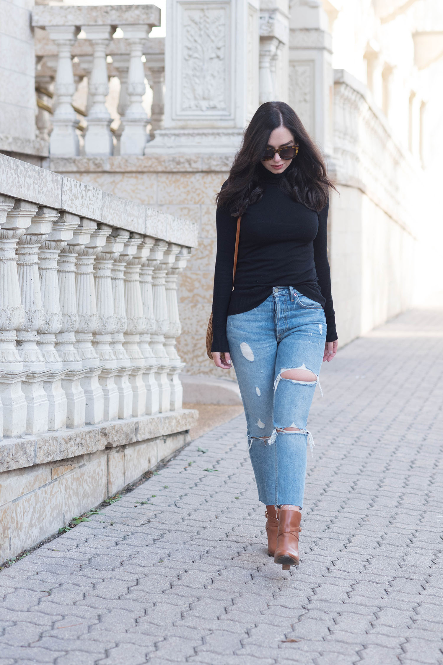 Fashion blogger Cee Fardoe of Coco & Vera walks by Fort Garry Place in Winnipeg wearing Grlfrnd jeans and Sezane ankle boots