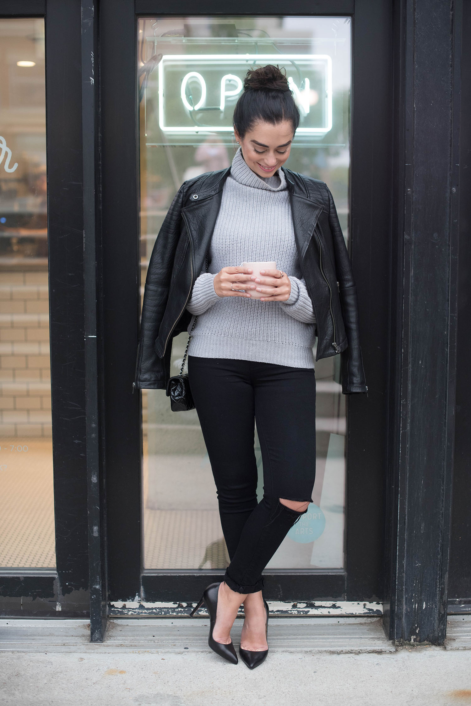 Winnipeg fashion blogger Cee Fardoe stands outside Little Sister Coffee wearing Paige jeans and an Aritzia sweater