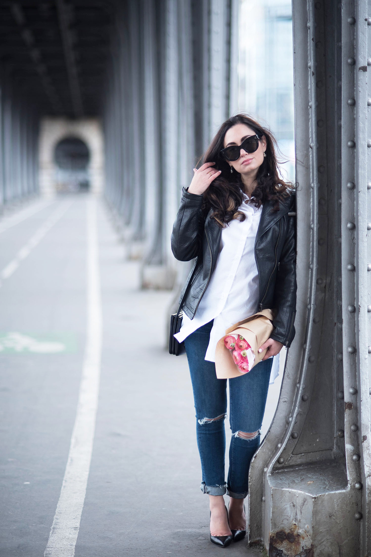 Fashion blogger Cee Fardoe of Coco & Vera stands under pont Bir Hakim in Paris wearing a Marled blouse and Celine Audrey sunglasses