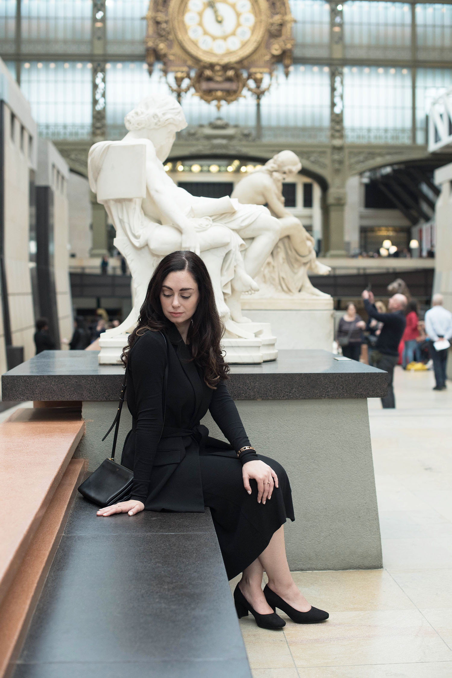 Fashion blogger Cee Fardoe of Coco & Vera sits at the Musee d'Orsay in Paris wearing a Zara waistcoat and carrying a Celine trio bag