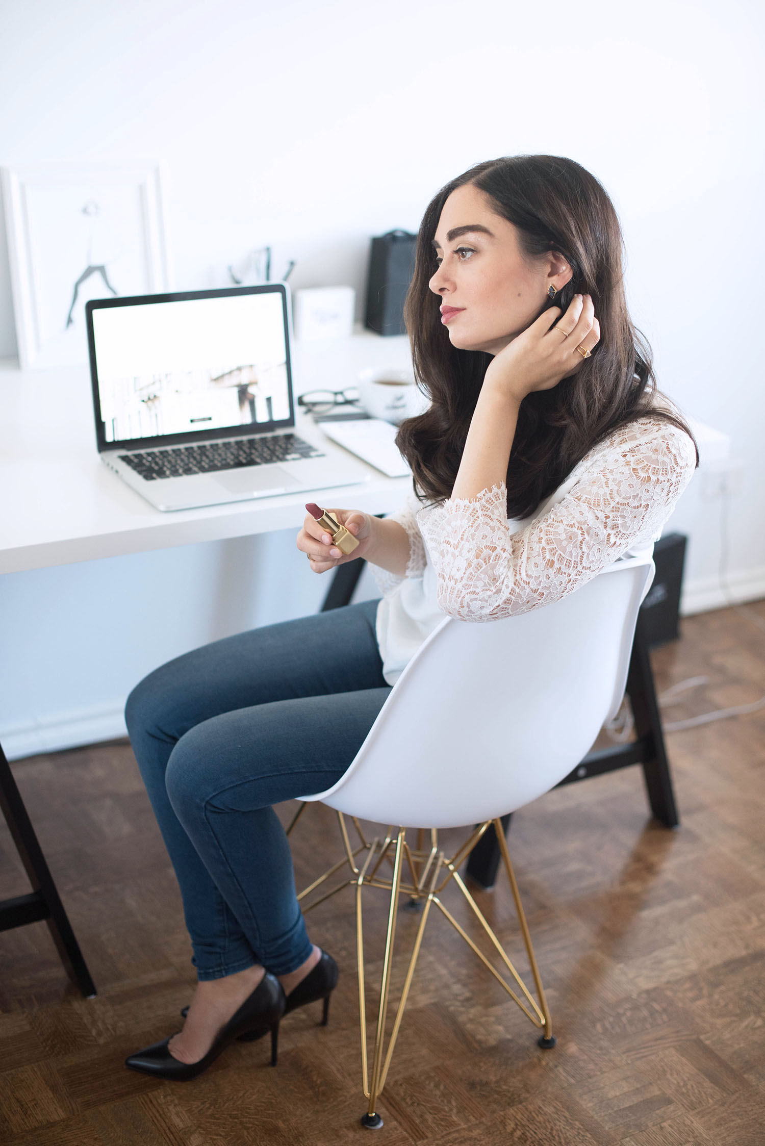 Fashion blogger Cee Fardoe of Coco & Vera sits in her home office wearing a white Sezane blouse and Mott & Bow blue jeans