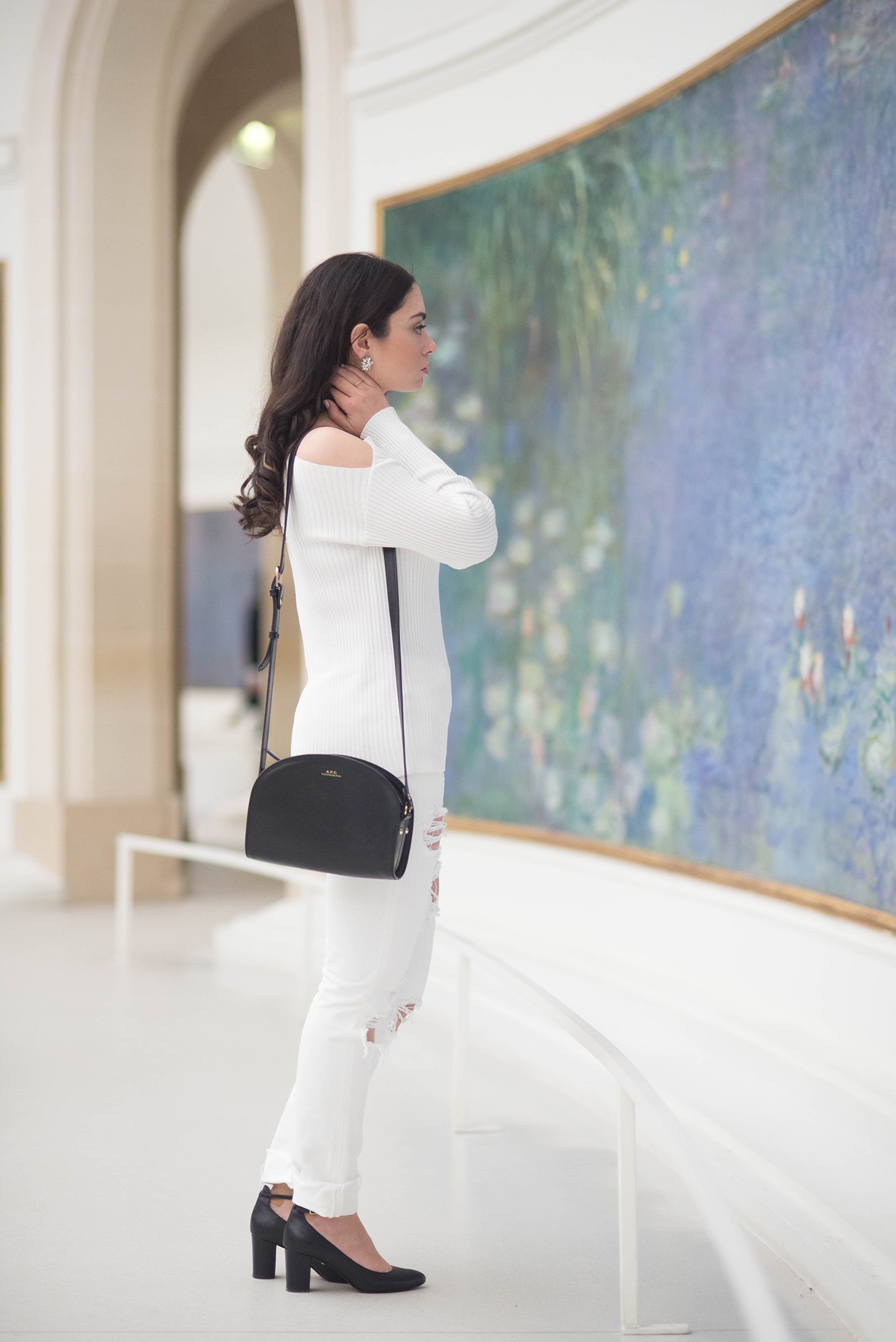Fashion blogger Cee Fardoe of Coco & Vera wears a Majorelle Twister sweater and carries an APC half moon bag at the Musee de l'Orangerie in Paris