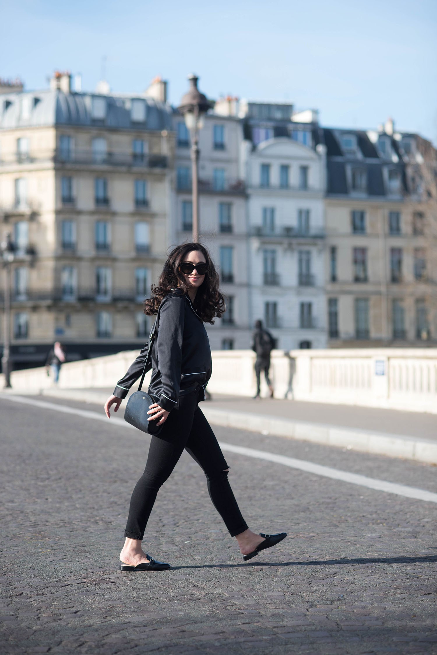 Fashion blogger Cee Fardoe of Coco & Vera crosses pont Louis-Philippe in Paris wearing Jonak mules and a Wear Elise pyjama top