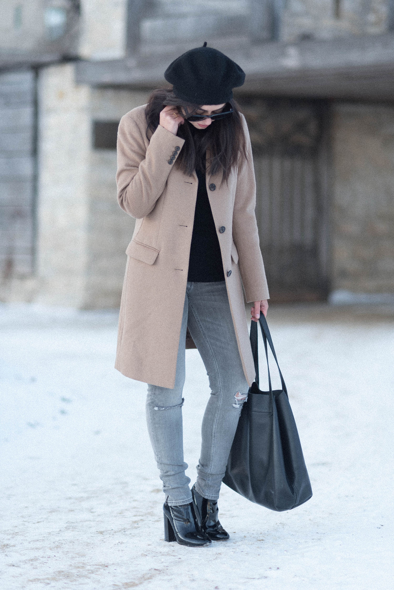 Canadian fashion blogger Cee Fardoe of Coco & Vera wearings a Uniqlo camel coat and Zara grey jeans at Fort Garry in Winnipeg