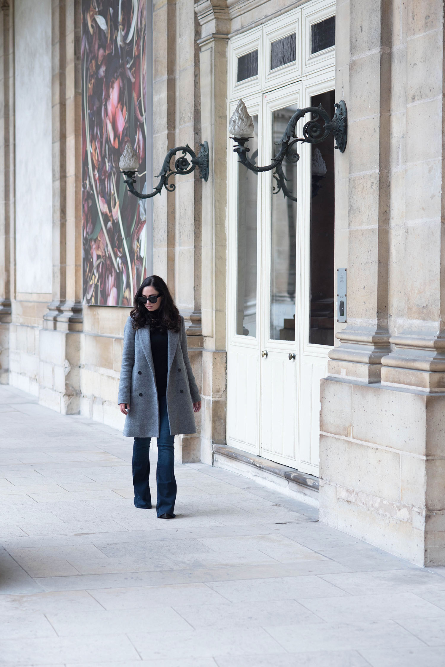 Fashion blogger Cee Fardoe of Coco & Vera walks through les Archives Nationales in Paris wearing Mavi flared jeans and Celine Audrey sunglasses