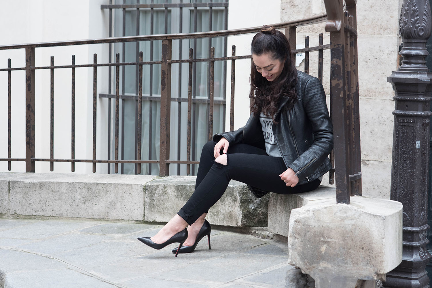Winnipeg fashion blogger Cee Fardoe of Coco & Vera sits outside the Palais Royal in Paris wearing a Cupcakes & Cashmere leather jacket and Christian Louboutin Pigalle pumps