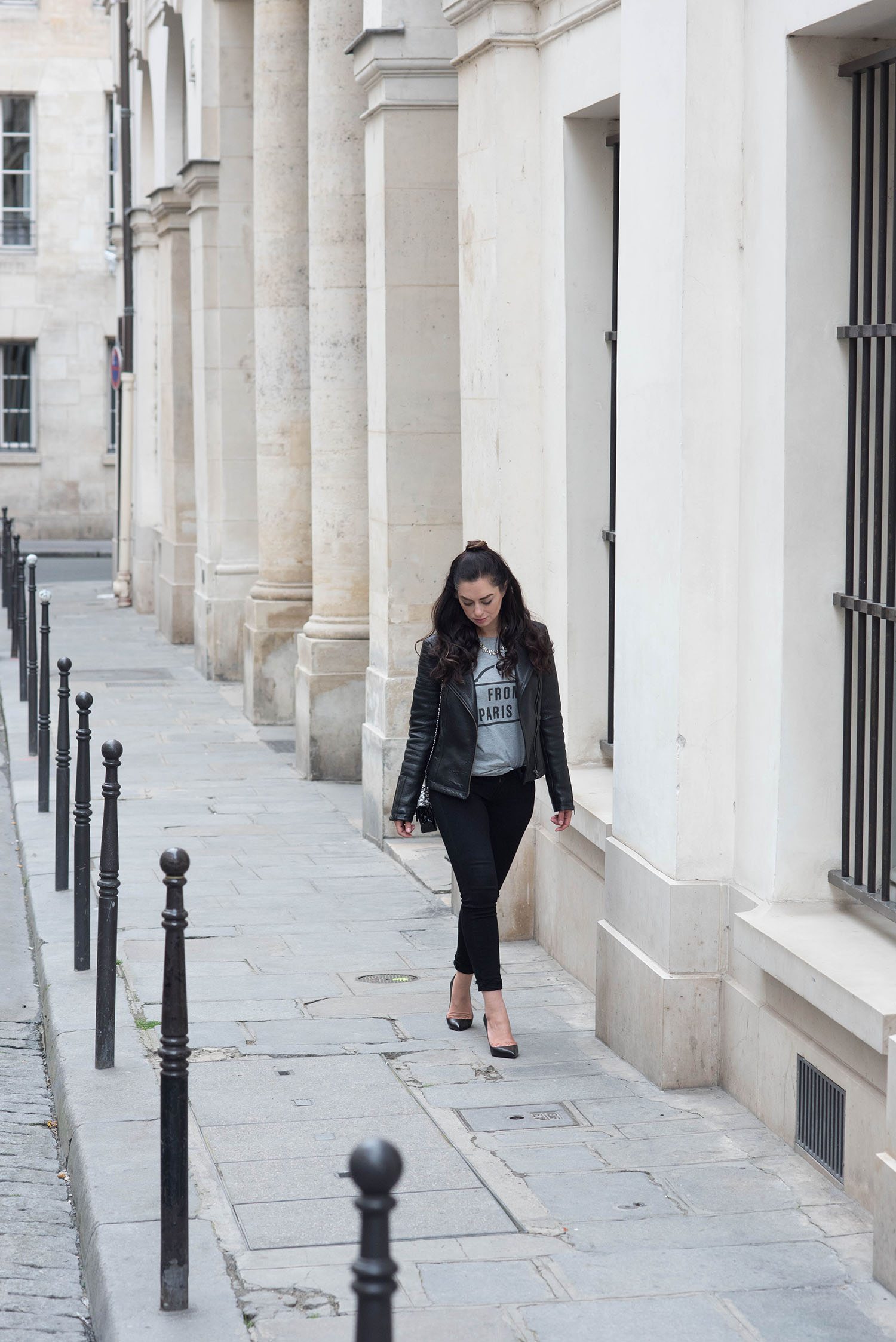 Canadian fashion blogger Cee Fardoe of Coco & Vera walks outside the Palais Royal wearing Paige jeans and Christian Louboutin Pigalle pumps