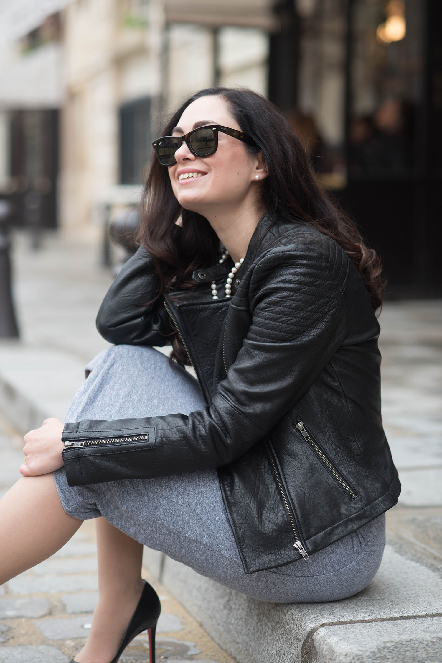 Portrait of Canadian fashion blogger Cee Fardoe of Coco & Vera at Place Dauphine in Paris, wearing a Cupcakes and Cashmere leather jacket and Rayban Wayfarer sunglasses