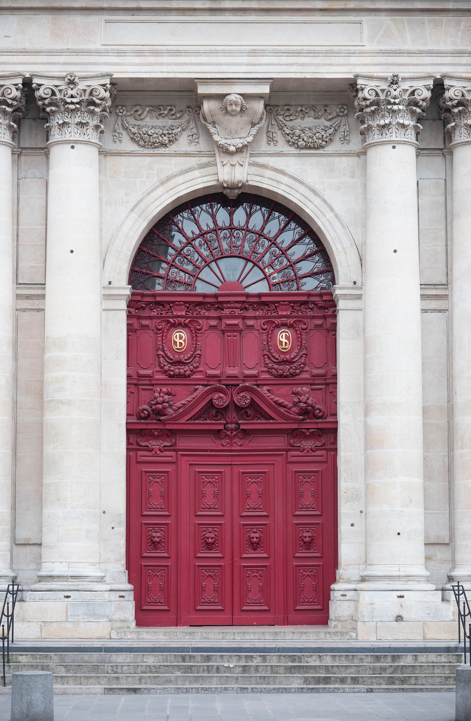 The ornate red door of a cathedral on rue de Rivoli in Paris, as photographed by Winnipeg travel blogger Cee Fardoe of Coco & Vera