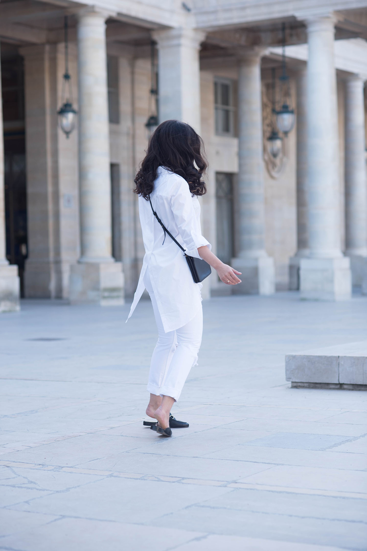 Canadian fashion blogger Cee Fardoe of Coco & Vera twirls in the Palais Royal, wearing Jonak mules and a Marled white blouse