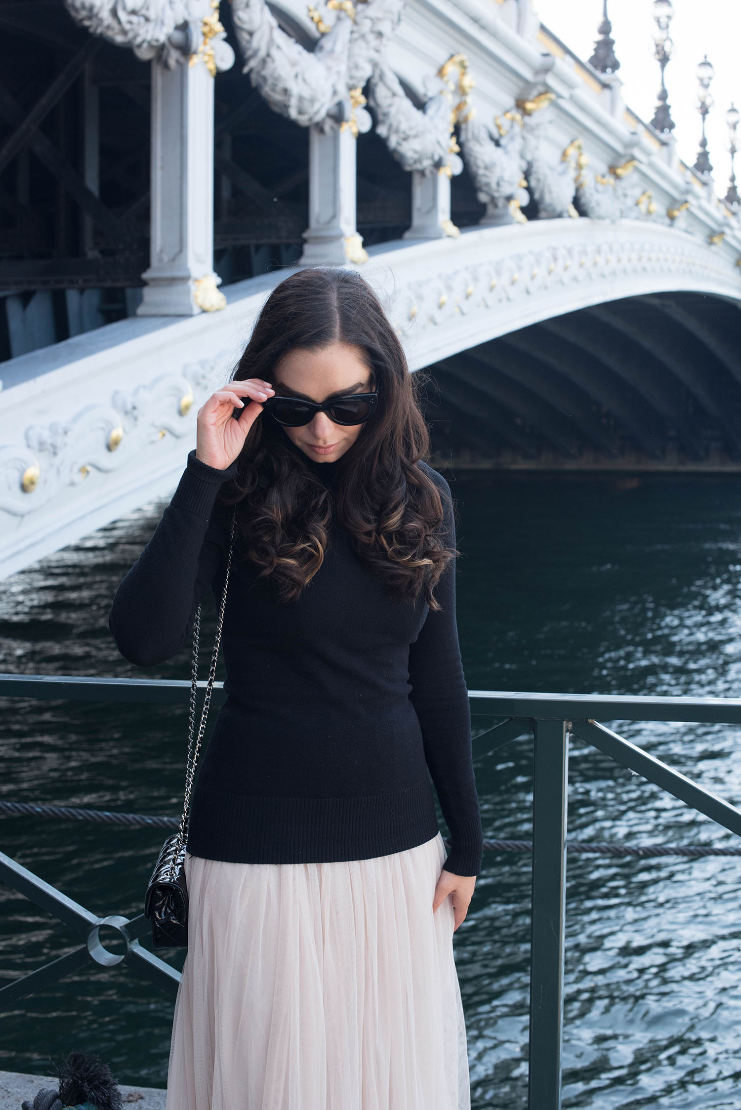 Portrait of brunette fashion blogger Cee Fardoe of Coco & Vera at Pont Alexandre III in Paris wearing Celine Audrey sunglasses and a Le Chateau sweater