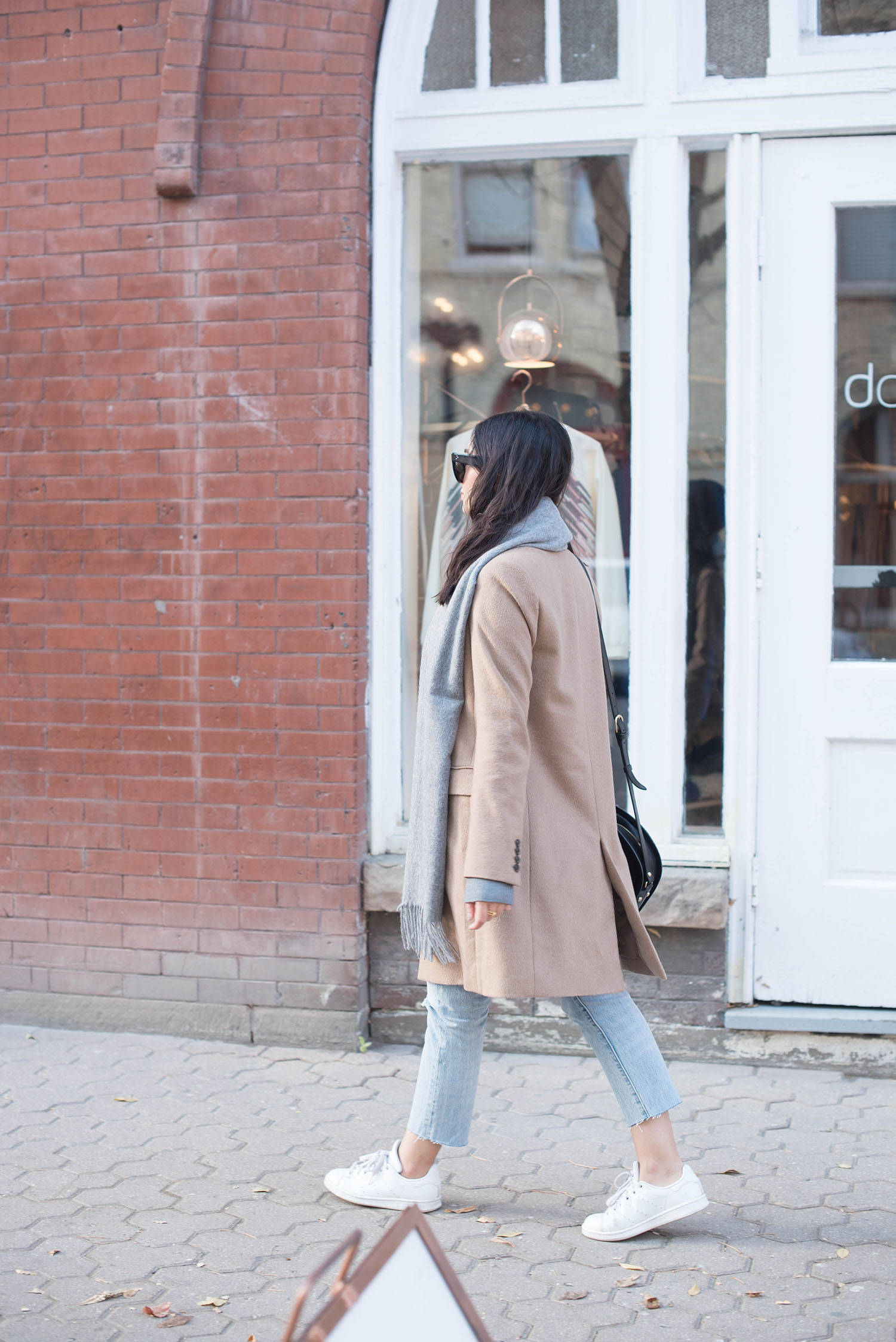 Winnipeg fashion blogger Cee Fardoe of Coco & Vera walks in the Exchange District in Winnipeg, wearing a Uniqlo camel coat and Levi's 501 skinny jeans