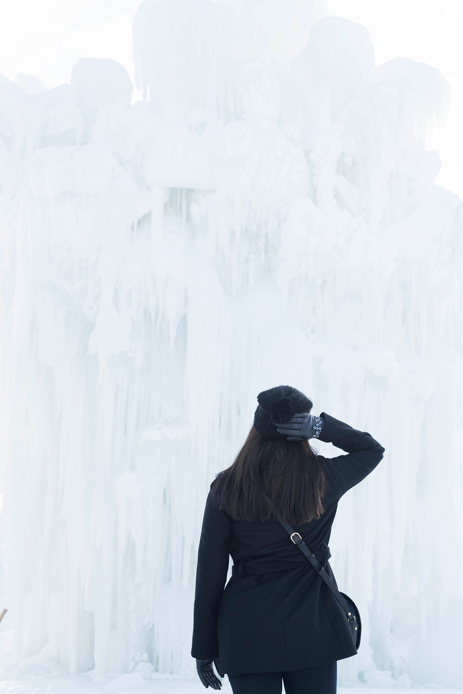 Winnipeg fashion blogger Cee Fardoe of Coco & Vera looks up at Ice Castles at the Forks in Winnipeg, wearing a Mango coat and carrying an APC half moon bag