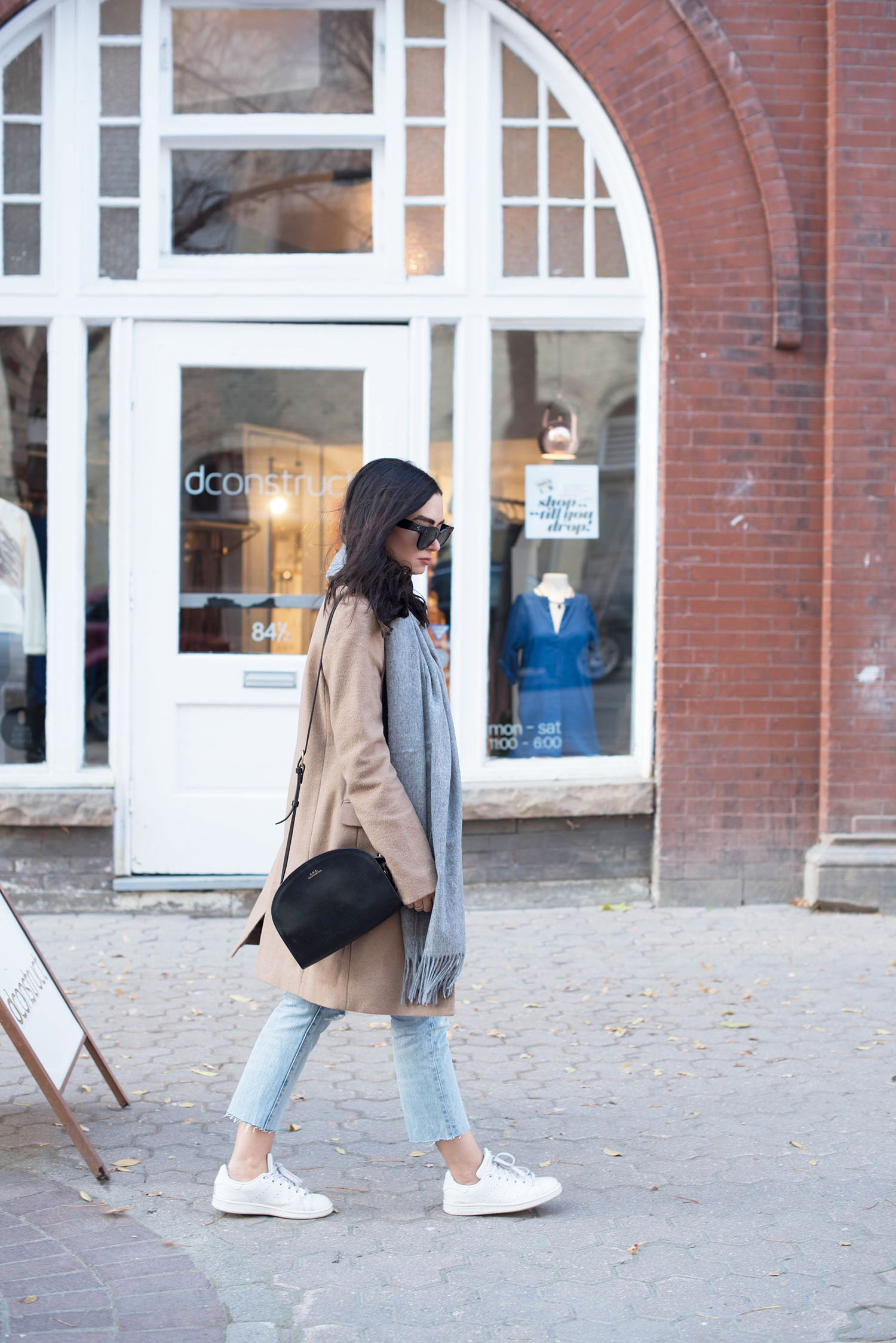 Winnipeg fashion blogger Cee Fardoe of Coco & Vera walks the streets of The Exchange District wearing a Uniqlo camel coat and carrying an APC half moon bag