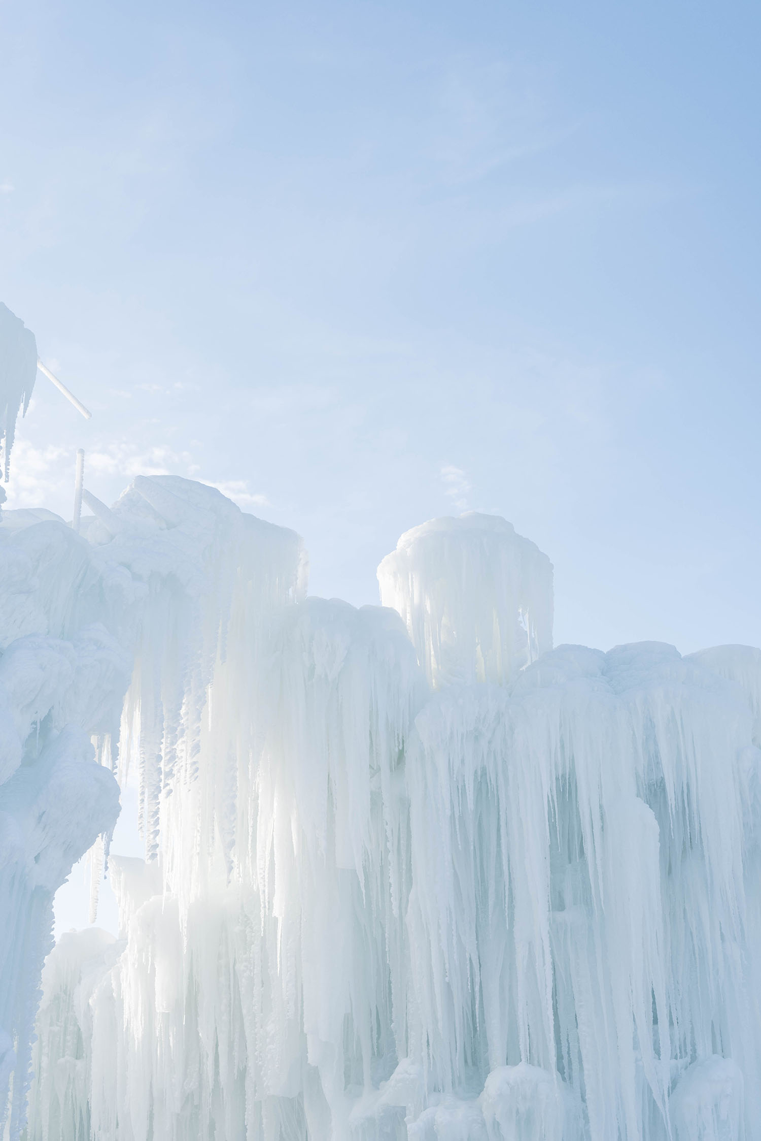 Sun shines through pillars of ice at Ice Castles in Winnipeg, as photographed by trop travel blogger Cee Fardoe of Coco & Vera
