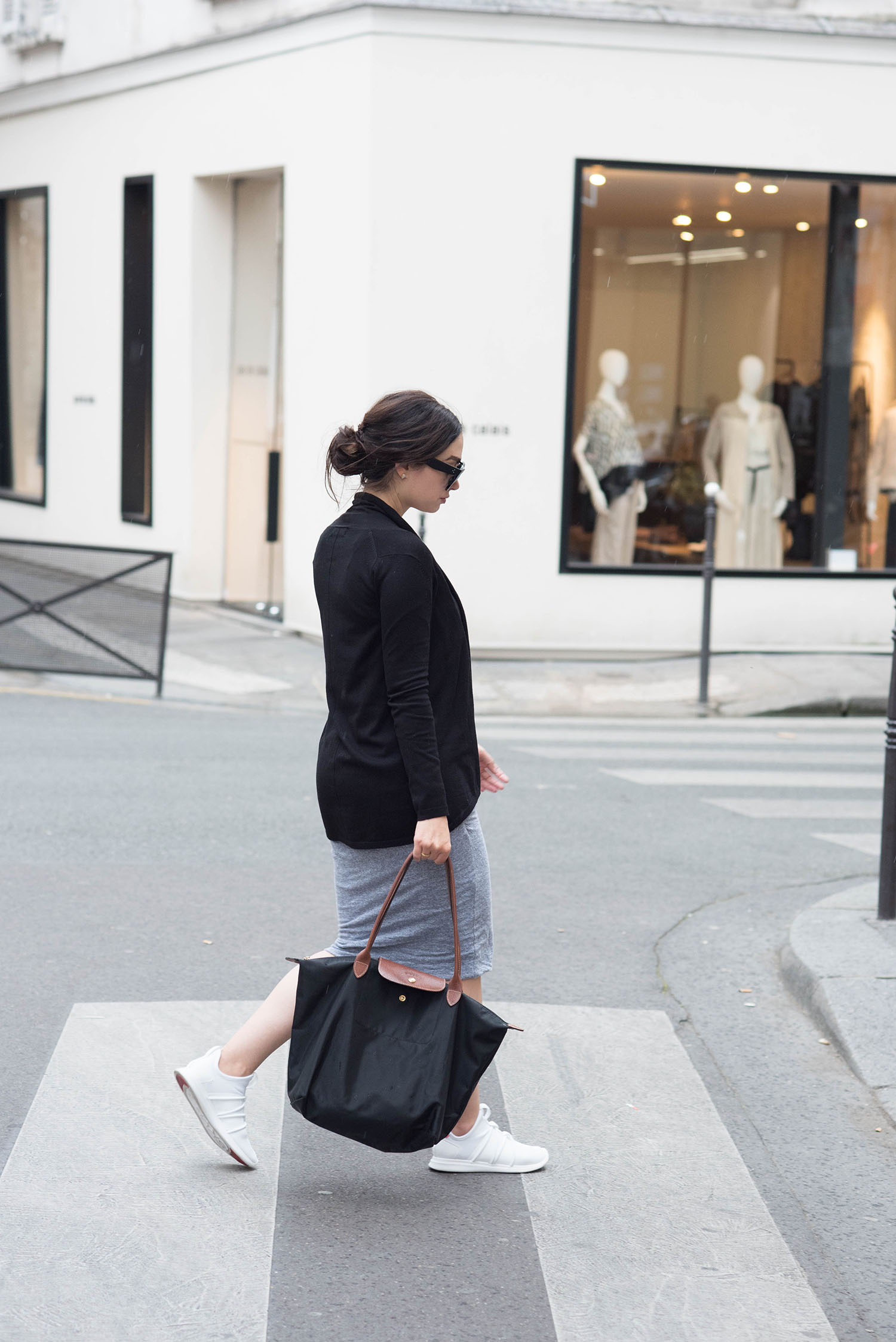 Fashion blogger Cee Fardoe of Coco & Vera walks in Paris wearing Skye Footwear sneakers and a grey Monrow dress