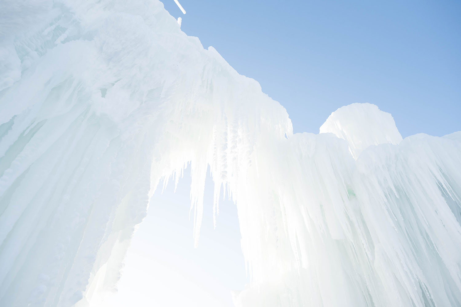 Ice formations under blue skies at Ice Castles in Winnipeg, Manitoba, as captured by travel blogger Cee Fardoe of Coco & Vera