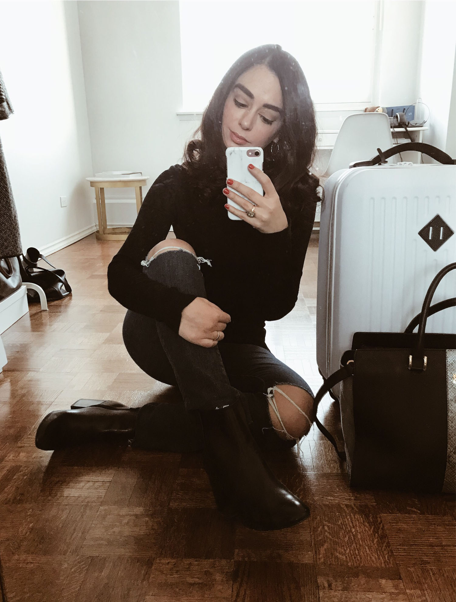 Canadian fashion blogger Cee Fardoe of Coco & Vera takes a selfie before a business trip to Toronto, wearing Paige jeans and sitting next to her Herschel white suitcase
