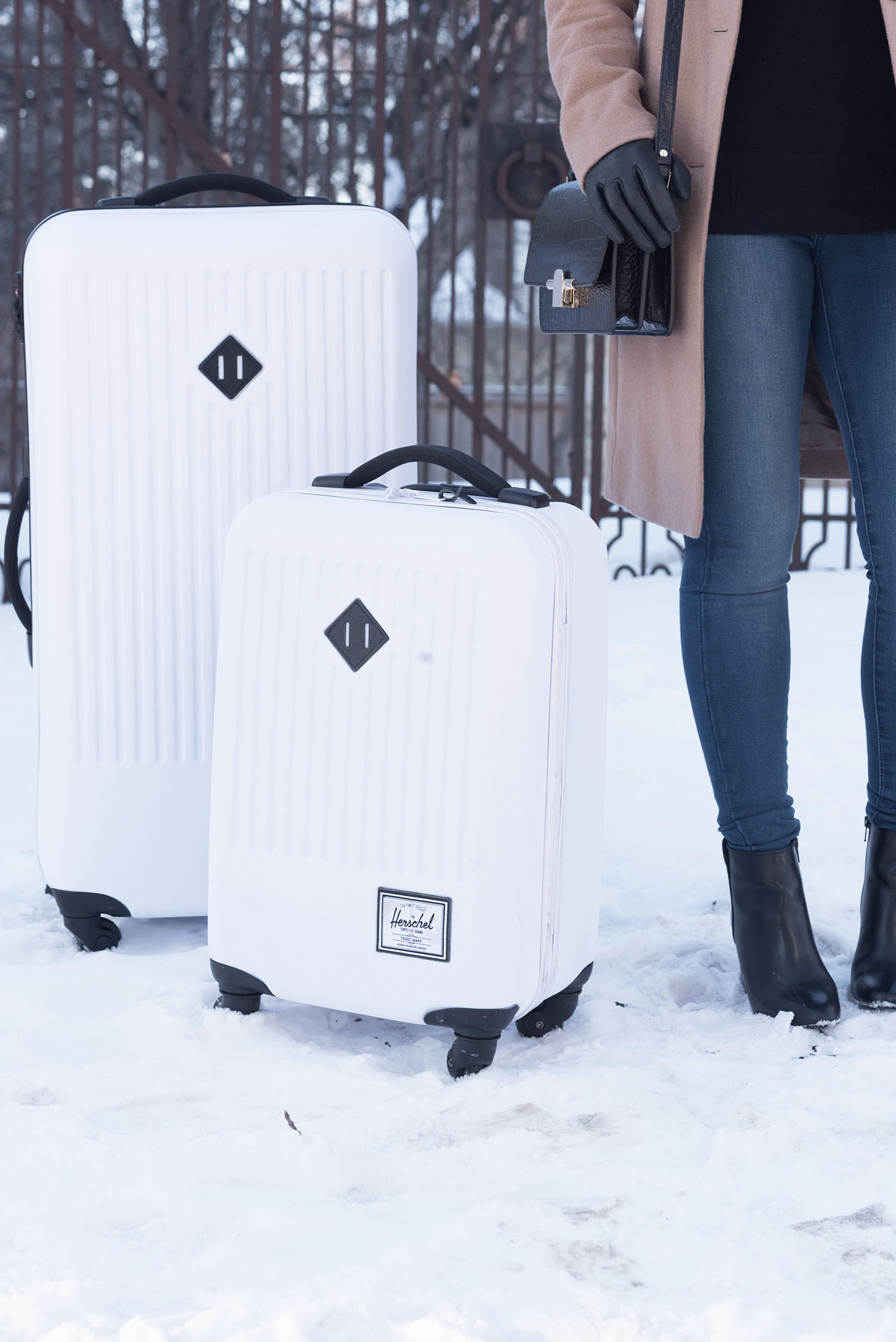 Outfit details on Canadian fashion blogger Cee Fardoe of Coco & Vera, including two white Herschel Supply Co. suitcases, Aldo boots and Mott & Bow jeans