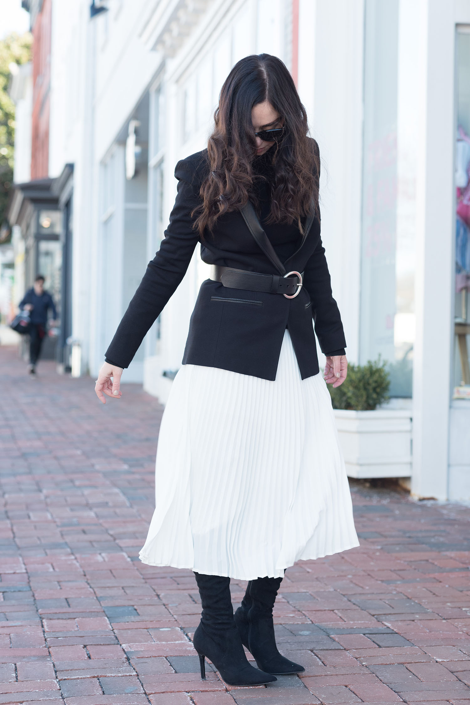 Canadian fashion blogger Cee Fardoe of Coco & Vera twirls in Washington DC wearing a white pleated skirt from Aritzia and a black Helmut Lang blazer