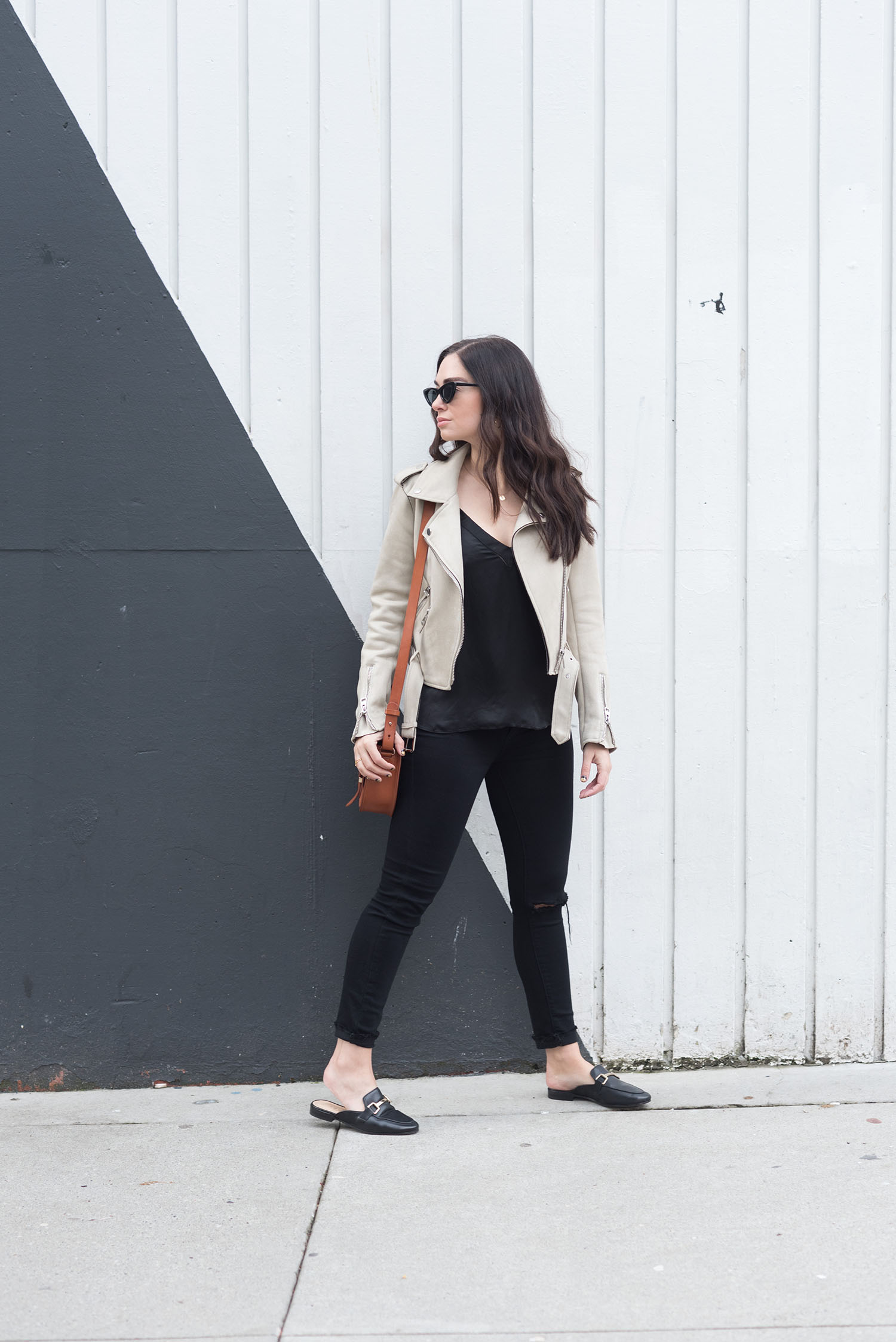 Fashion blogger Cee Fardoe of Coco & Vera walks outside the Burrard Hotel in Vancouver wearing Paige black jeans and an Aritzia silk tank