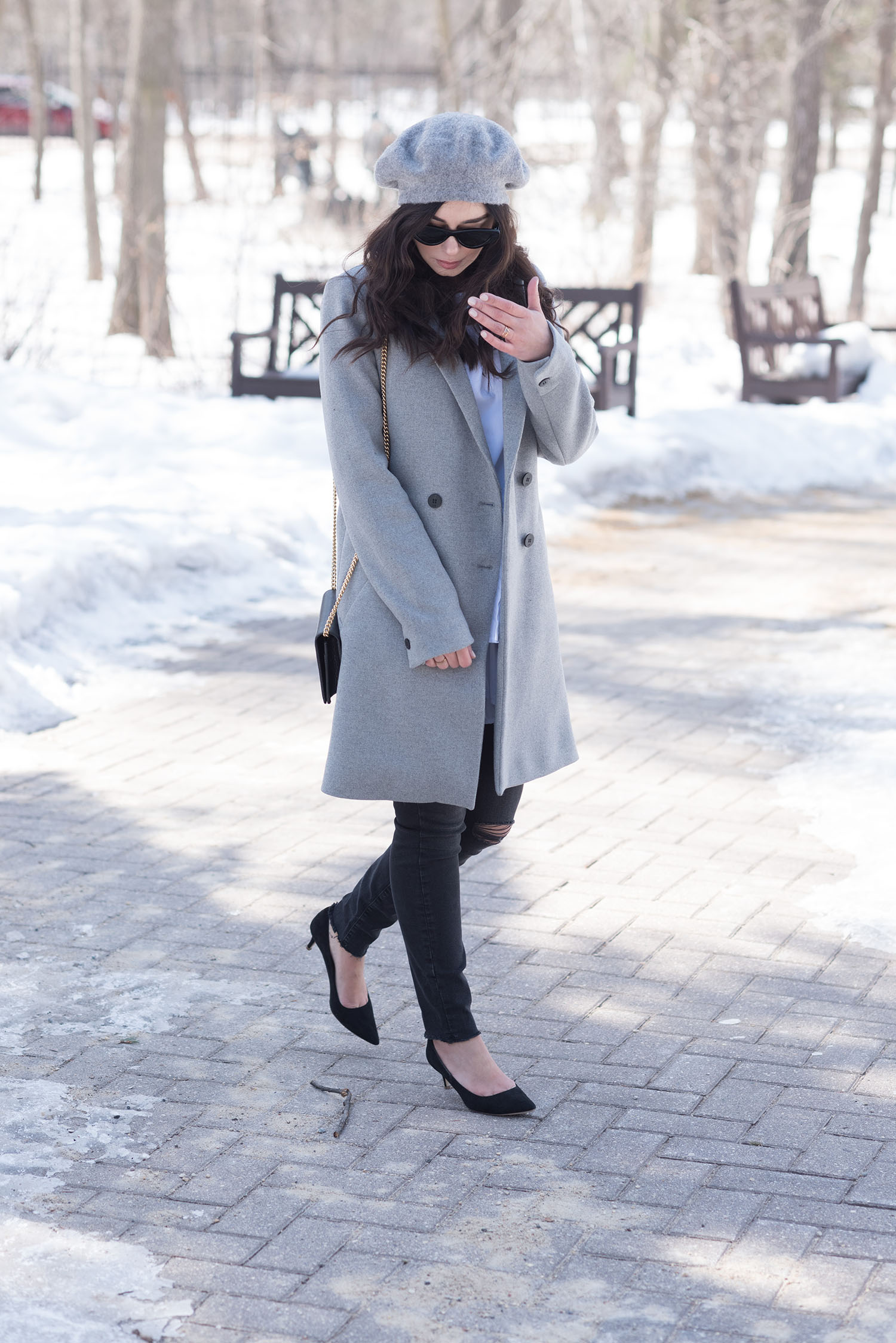 Fashion blogger Cee Fardoe of Coco & Vera walks through the Leo Mol Garden in Winnipeg wearing a Zara grey coat and Mavi skinny jeans