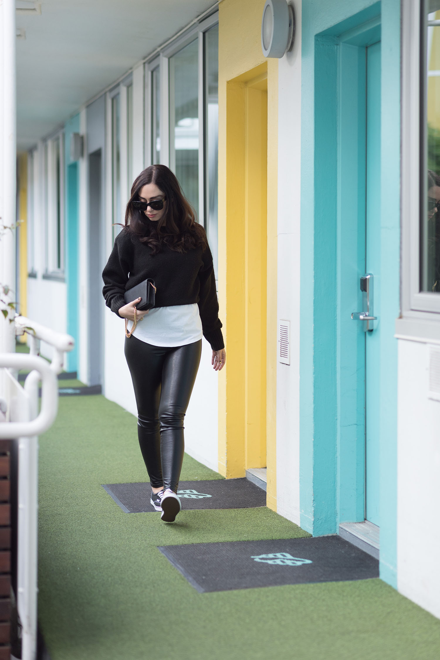 Fashion blogger Cee Fardoe of Coco & Vera walks the courtyard of The Burrard Hotel wearing an & Other Stories black sweater
