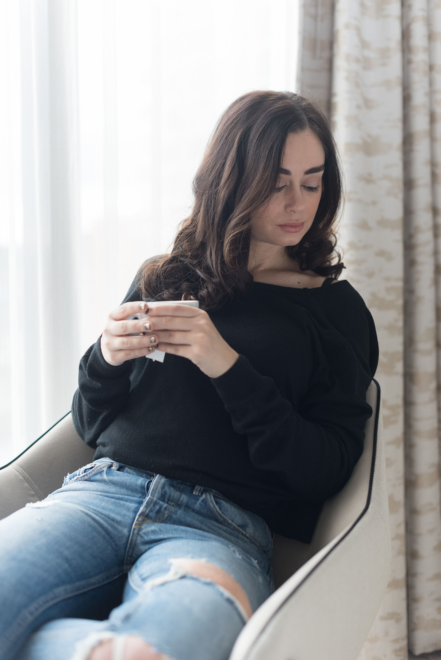 Portrait of fashion blogger Cee Fardoe of Coco & Vera at the JW Marriott Hotel in Vancouver, wearing an ASOS black sweater and Grlfrnd Karolina jeans